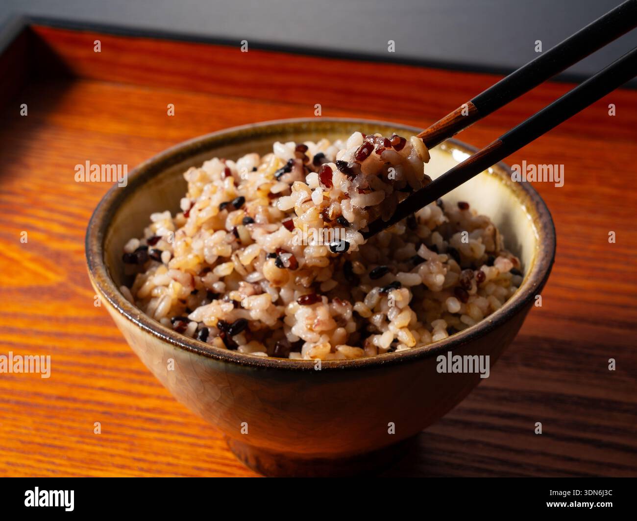 Ciotola di riso multigrano giapponese con bastoncini su un vassoio di legno, mangiare sano Foto Stock