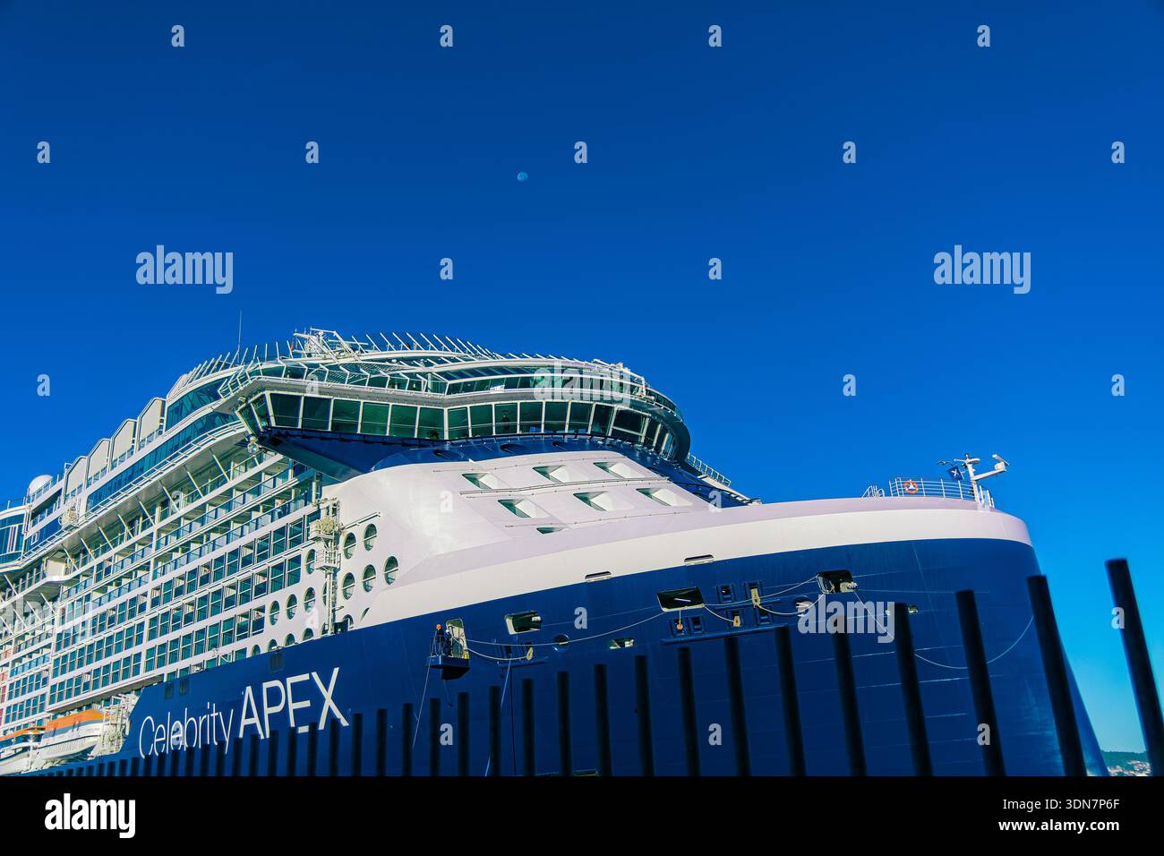 Ottobre 2025; Vigo, Galizia, Spagna: Nave da crociera Celebrity APEX prua e ponte visto attraverso la recinzione del porto con la luna in cielo limpido Foto Stock
