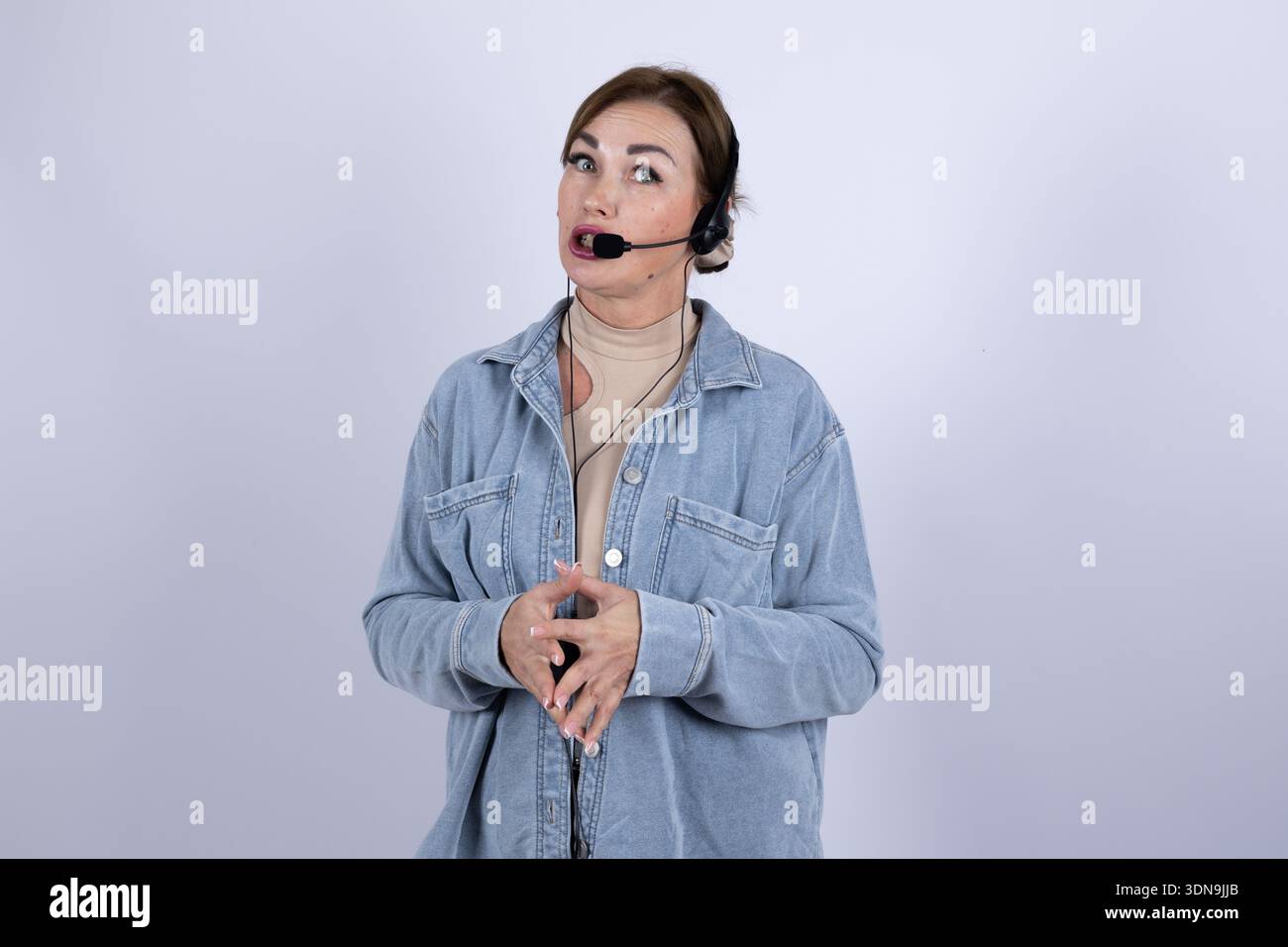 Presentatore femminile con cuffia che parla in studio Foto Stock