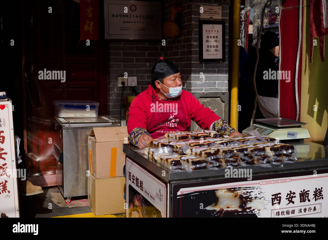 Il venditore ambulante vende dolci confezionati al mercato di Yongxingfang a Xi'an Foto Stock