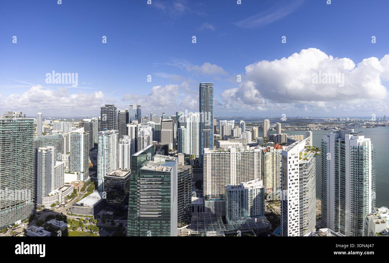 Veduta aerea di scintillanti grattacieli che perforano lo skyline, contrastando con il mare blu profondo oltre, un vivace arazzo della vita urbana, Brickell, Miami Foto Stock