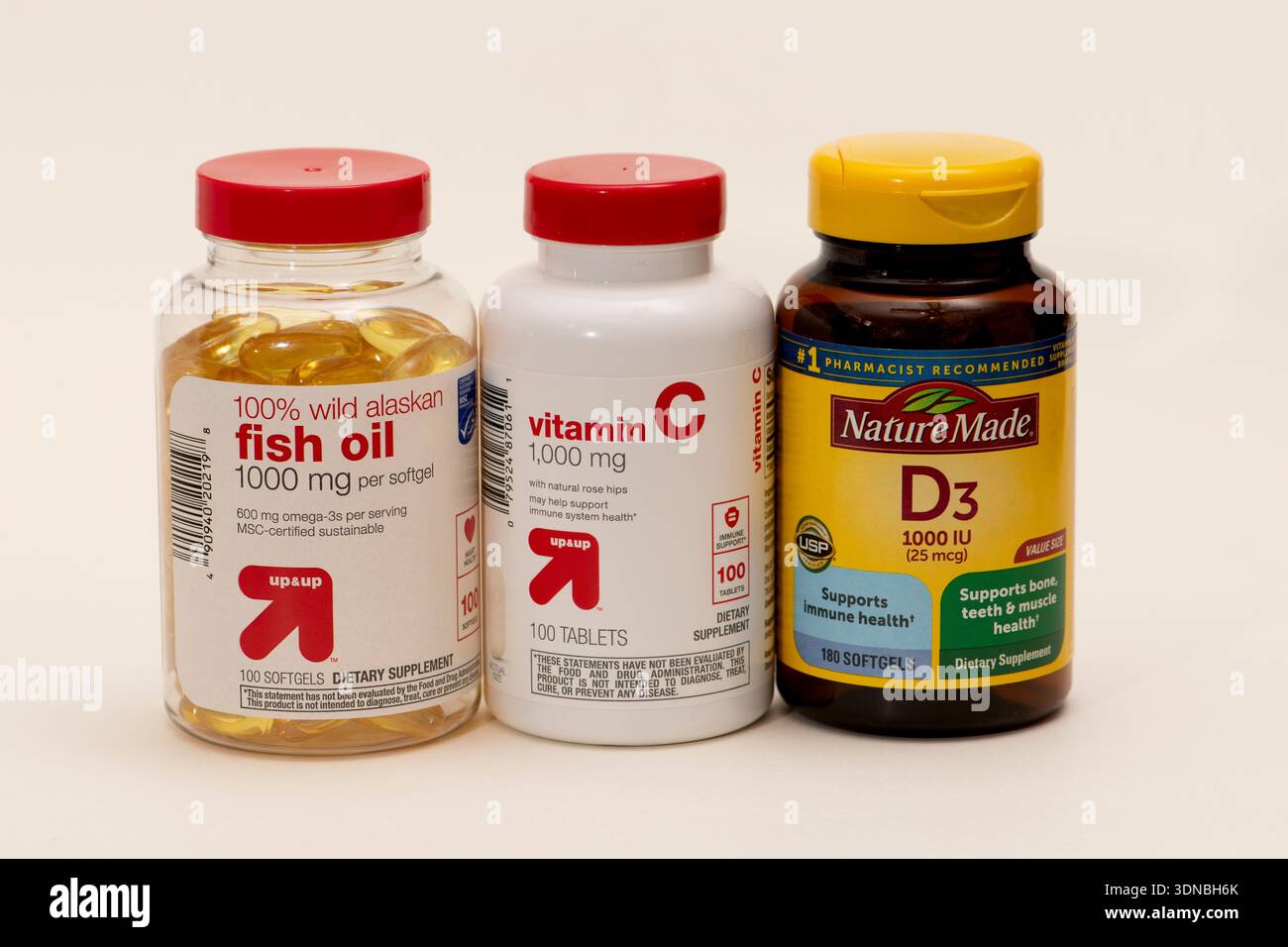 Primo piano di una bottiglia del marchio Target UP&UP di Wild Alaskan Fish Oil. E la vitamina c e una bottiglia di Nature hanno creato vitamina D3 su sfondo bianco Foto Stock