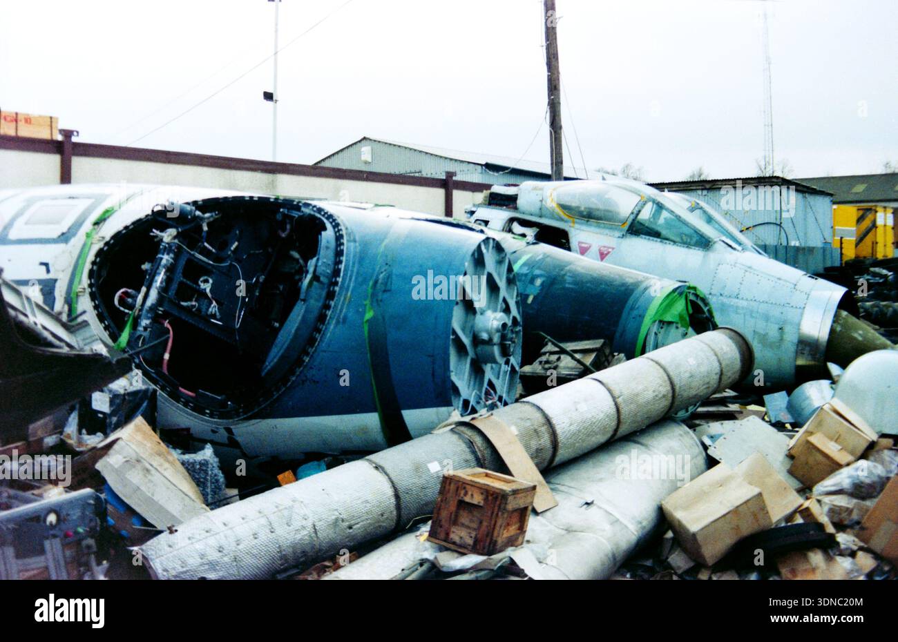 Ex bombardieri e aerei da combattimento della Royal Air Force English Electric Canberra e Lightning F6 presso il deposito rottami Hanningfield Metals, Essex, Regno Unito. Sezioni di naso degli aerei a reazione RAF degli anni '1960 ridotte a parti circondate da pezzi di ricambio e scatole Foto Stock