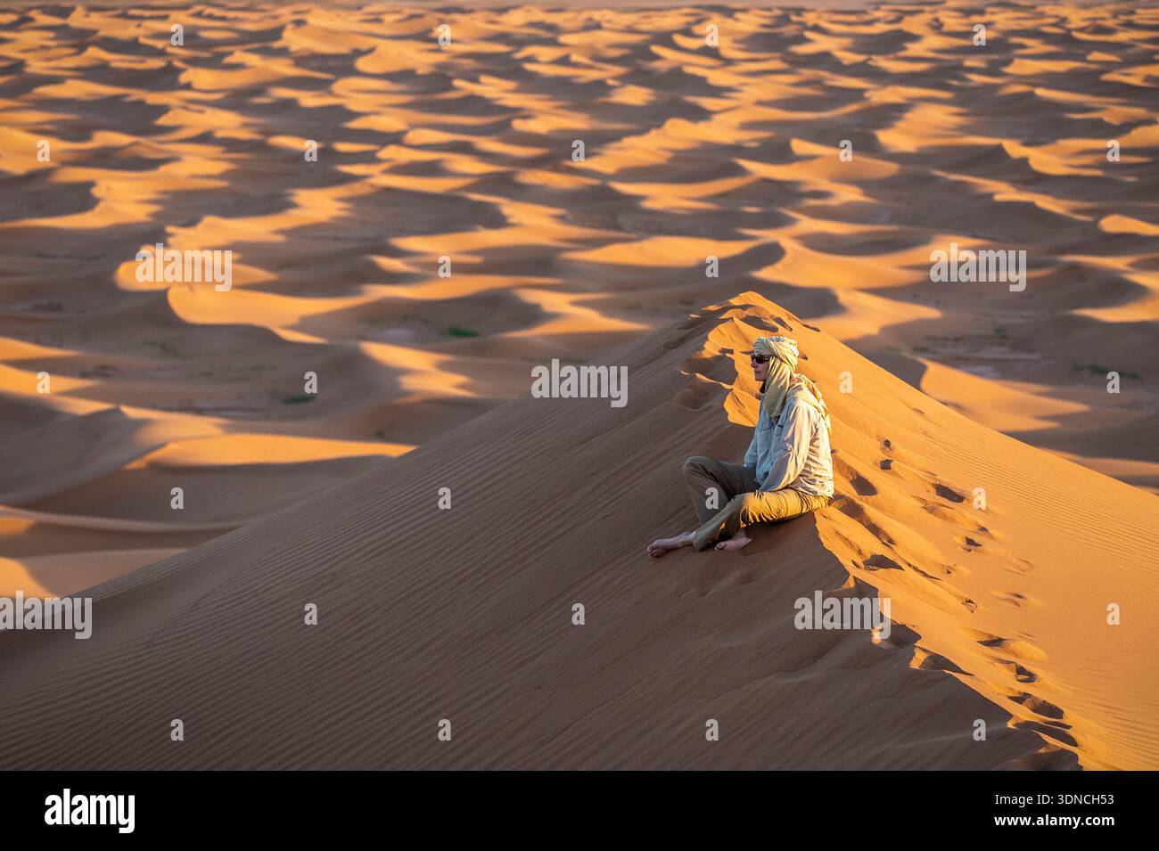 Marocco, Sahara, regione di Drâa-Tafilalet, M'Hamid El Ghizlane, Erg El Rhoul, trekking sulle dune, meditazione sulla cima di una duna Foto Stock