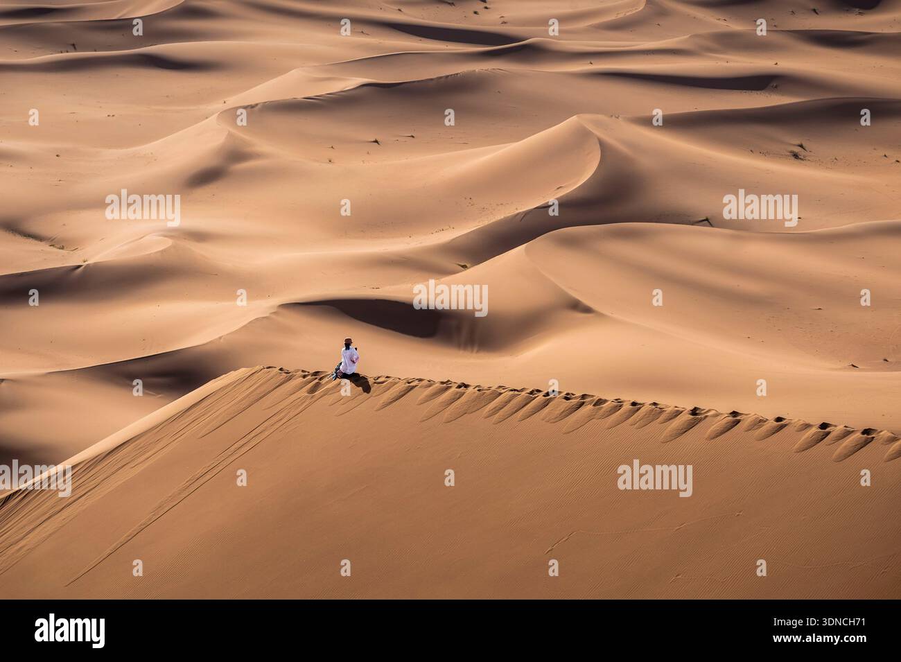 Marocco, Sahara, regione di Drâa-Tafilalet, M'Hamid El Ghizlane, Erg Lâabidlya, trekking sulle dune, meditazione sulla cima di una duna Foto Stock