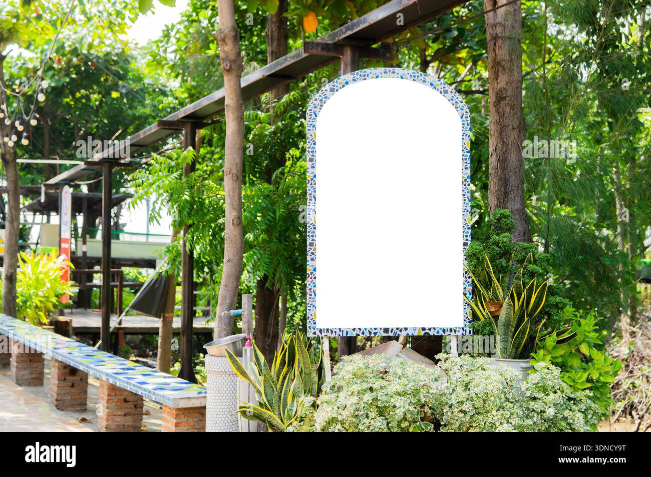 La bacheca informativa con struttura Mosaic bianca vuota e spazio mock-up si staglia contro l'esterno della foresta. Copia spazio. Foto Stock