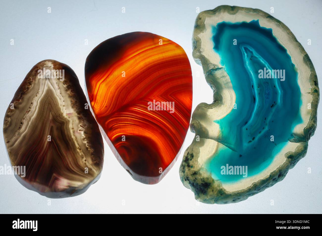 composizione di tre pietre di agata lucidate nei toni blu, rosso e marrone. Foto Stock