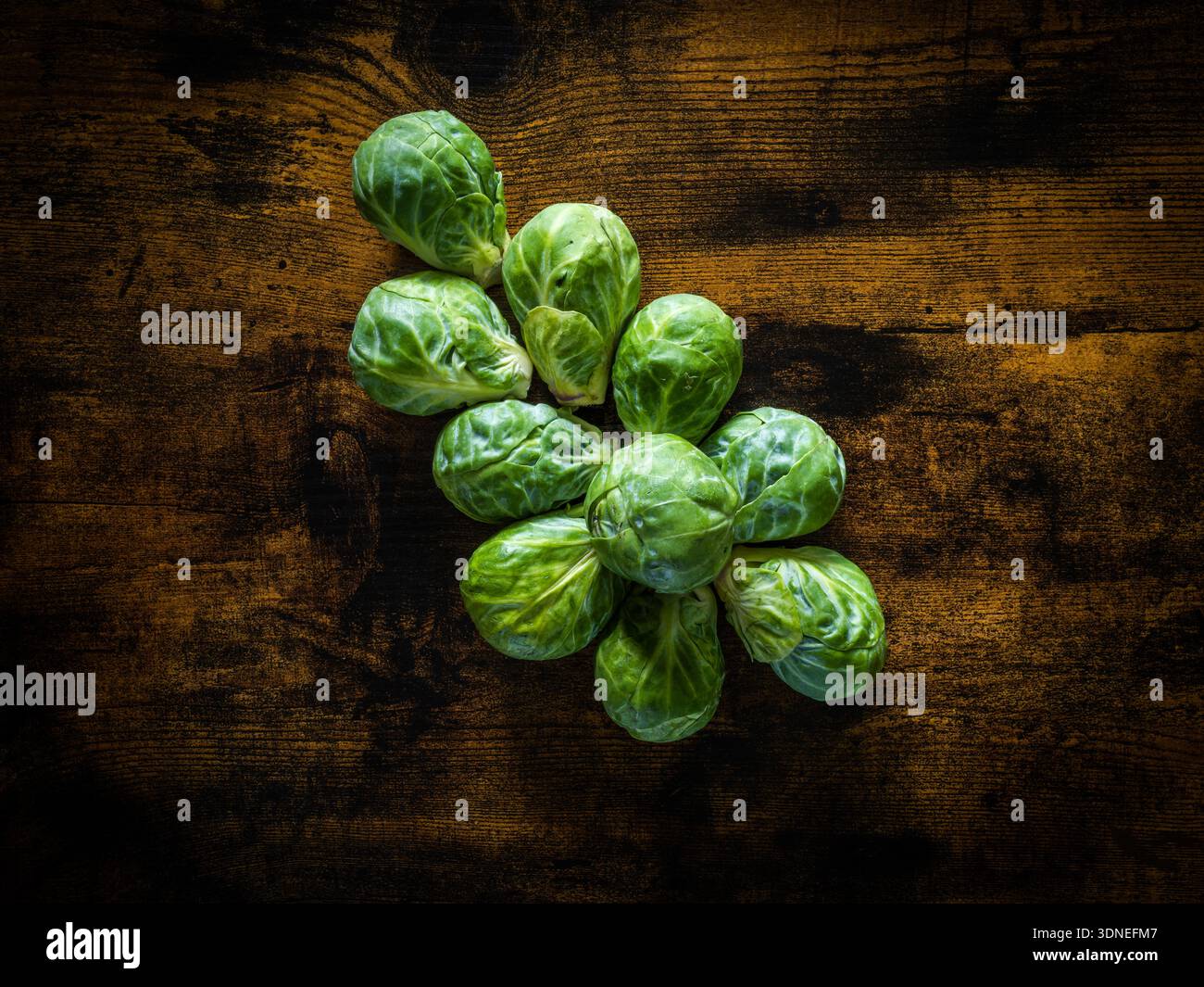 Des choux de bruxelles posés sur une table en bois Foto Stock