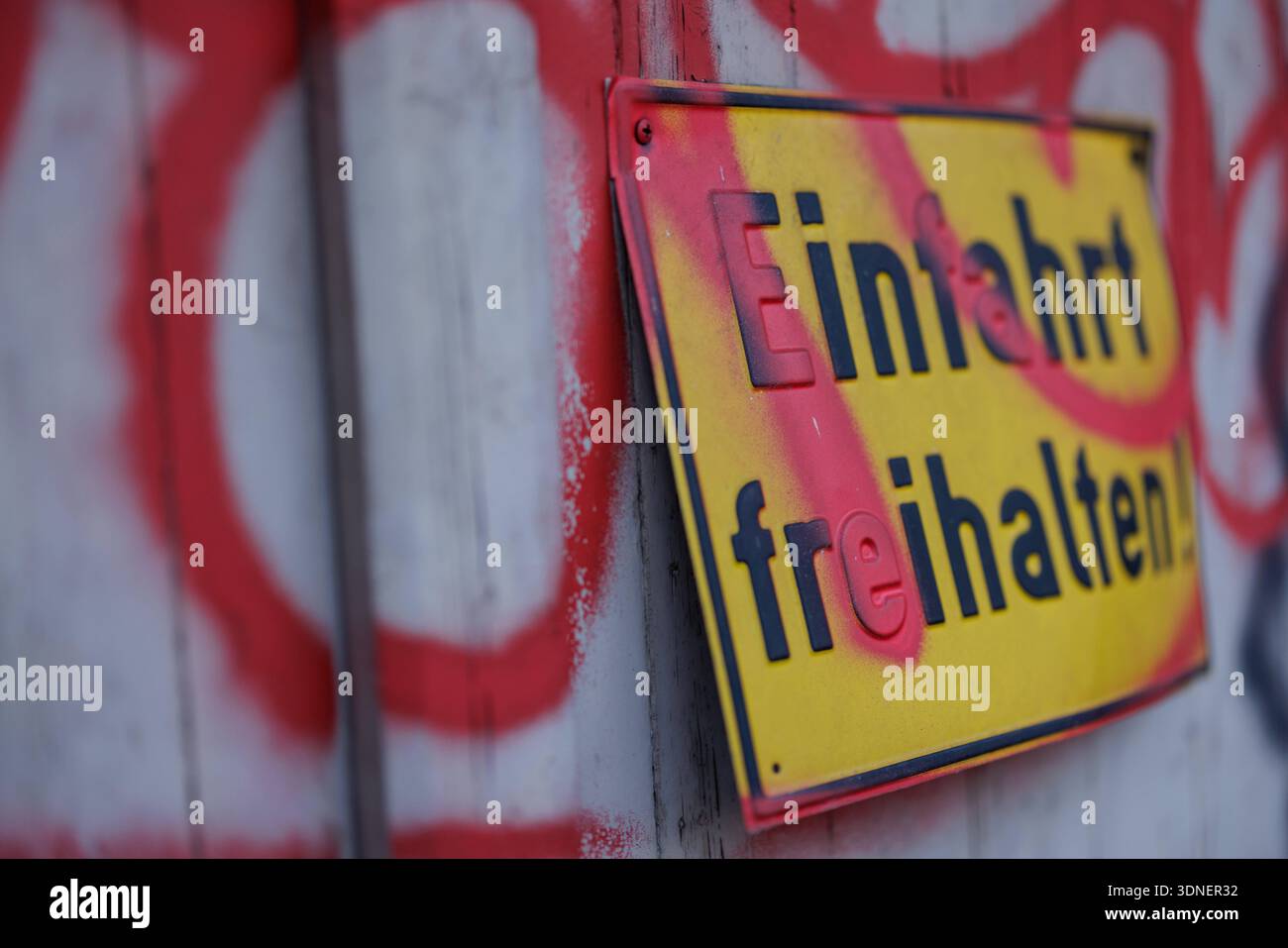 Einfahrt freihalten - Ein gelbes Hinweisschild mit der Aufschrift *Einfahrt freihalten*, das teilweise mit rotem Graffiti übersprüht wurde, hängt am 09.02.2026 an dem Holztor einer Garage in der Innenstadt von Osnabrück Niedersachsen, Deutschland. *** Einfahrt freihalten Un cartello giallo con l'iscrizione Einfahrt freihalten , parzialmente spruzzata con graffiti rossi, è appeso al cancello di legno di un garage nel centro della città di Osnabrück bassa Sassonia, Germania, il 09 02 2026 Foto Stock