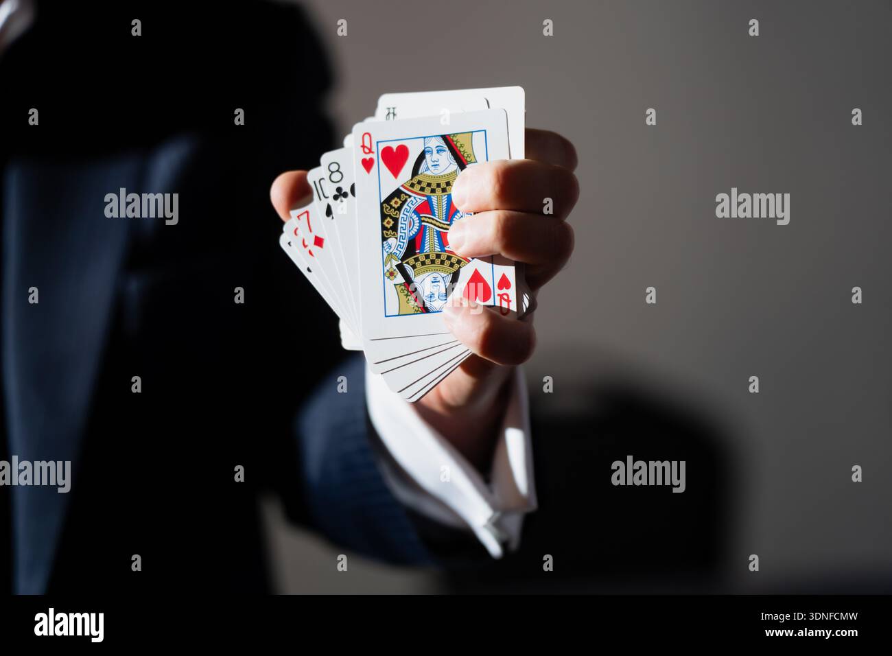 Concetto di illusione scenica che mostra le carte da poker affettate a mano, la regina dei cuori, le ombre forti e lo sfondo minimo per gli spot Foto Stock