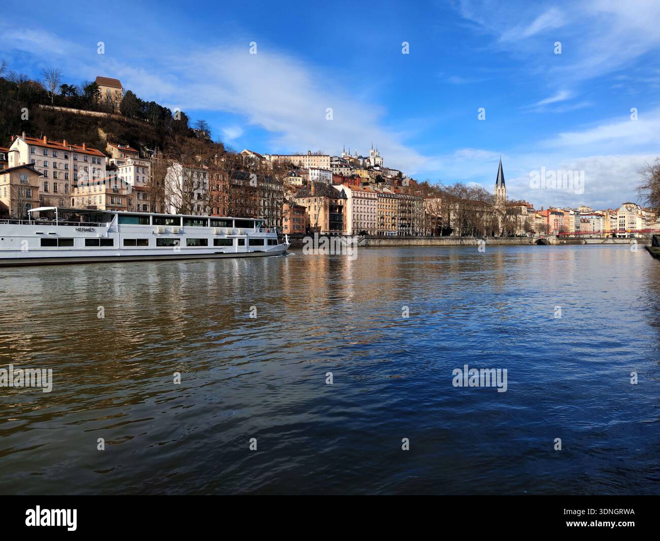 Lione, Francia - febbraio 6,2026: Il piroscafo fluviale passa per il fiume Saone vicino alla chiesa Saint-Georges nella città vecchia di Lione Foto Stock