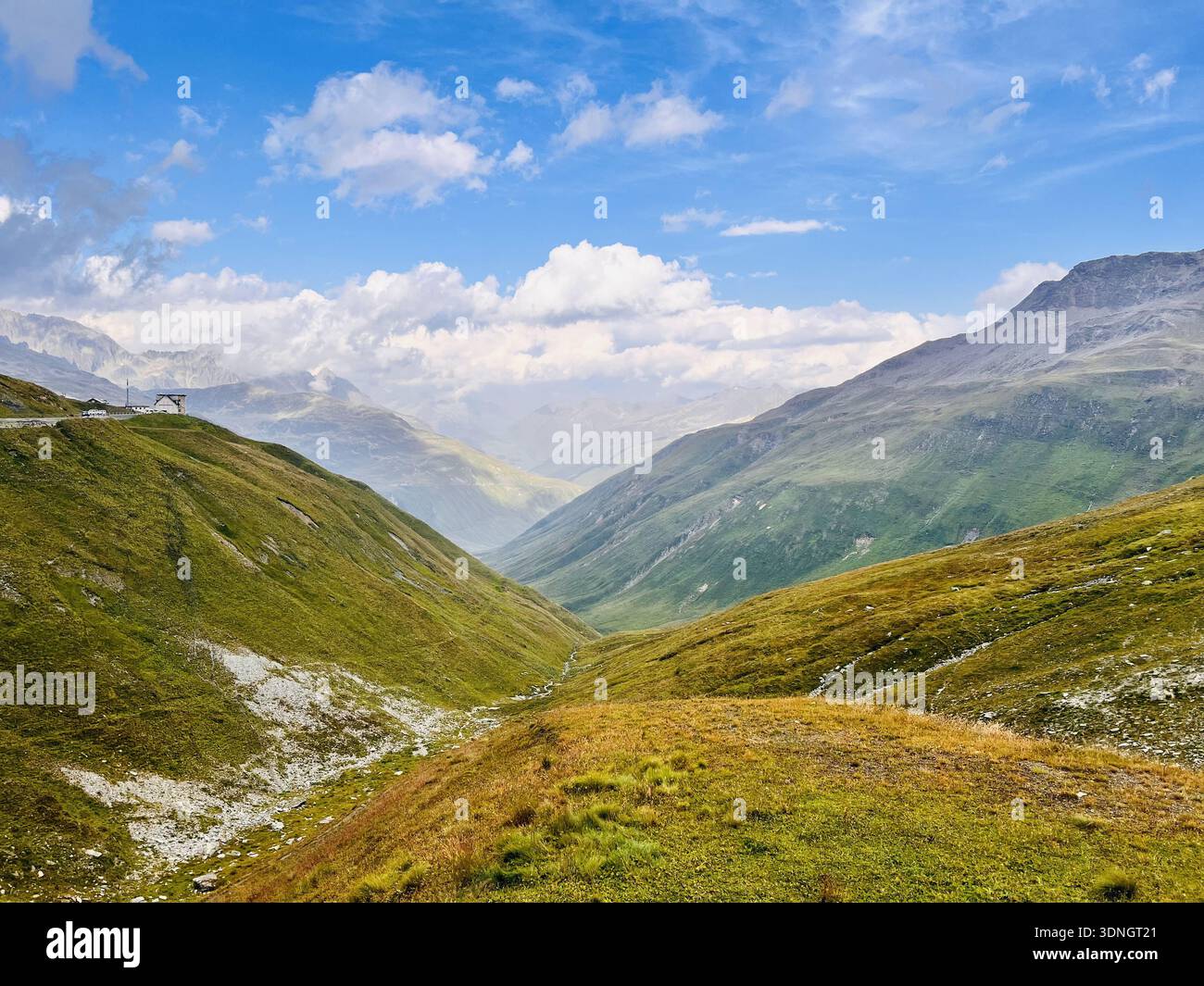 Panoramica della Alpine Valley con Rolling Green Hills e Rugged Mountain Peaks - Immagine stock catturata con smartphone