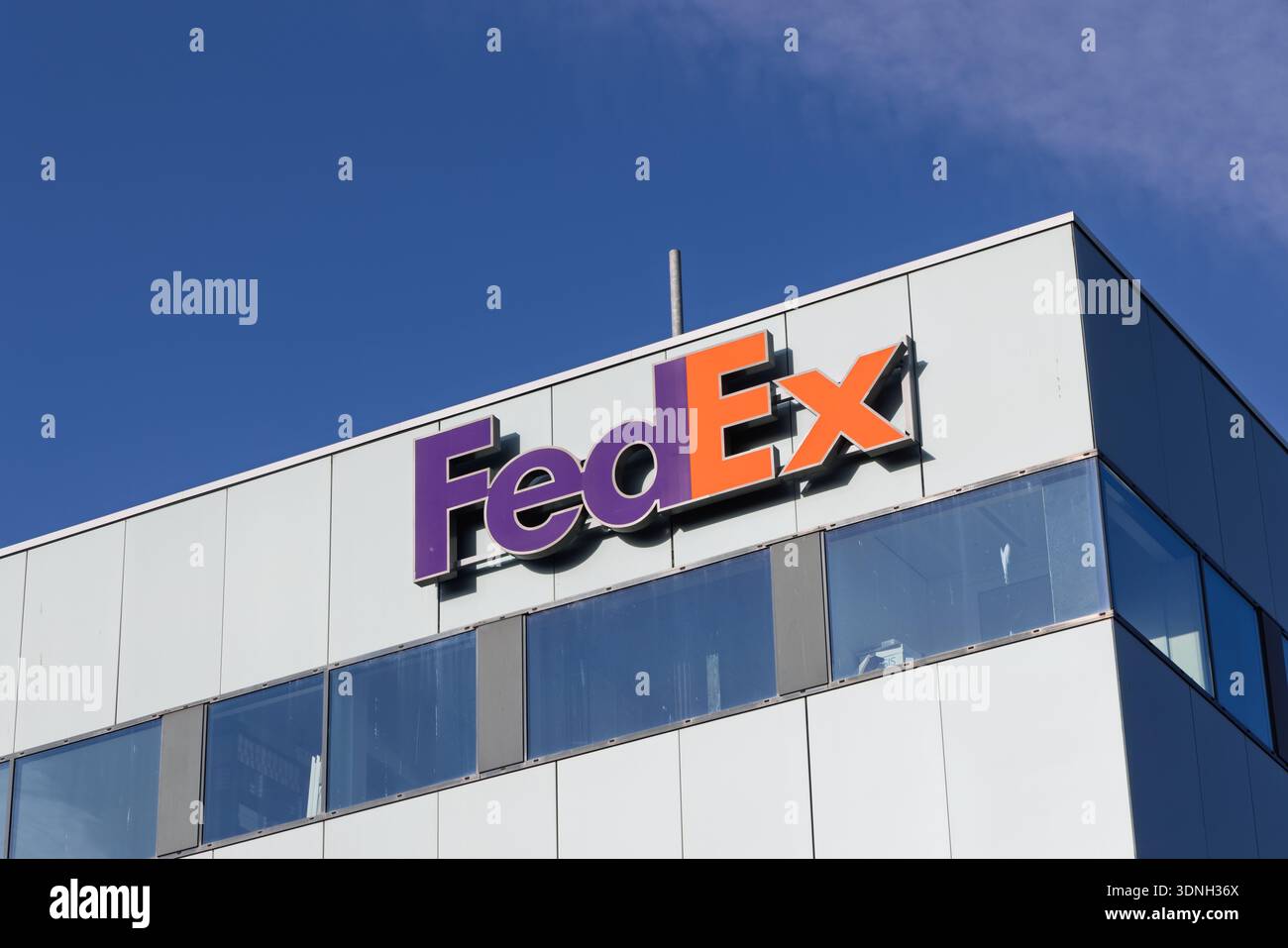 Primo piano del logo aziendale FedEx su un moderno edificio di uffici esterno, con un cielo azzurro nel quartiere degli affari di Hoofddorp. Hoofddorp, Neth Foto Stock