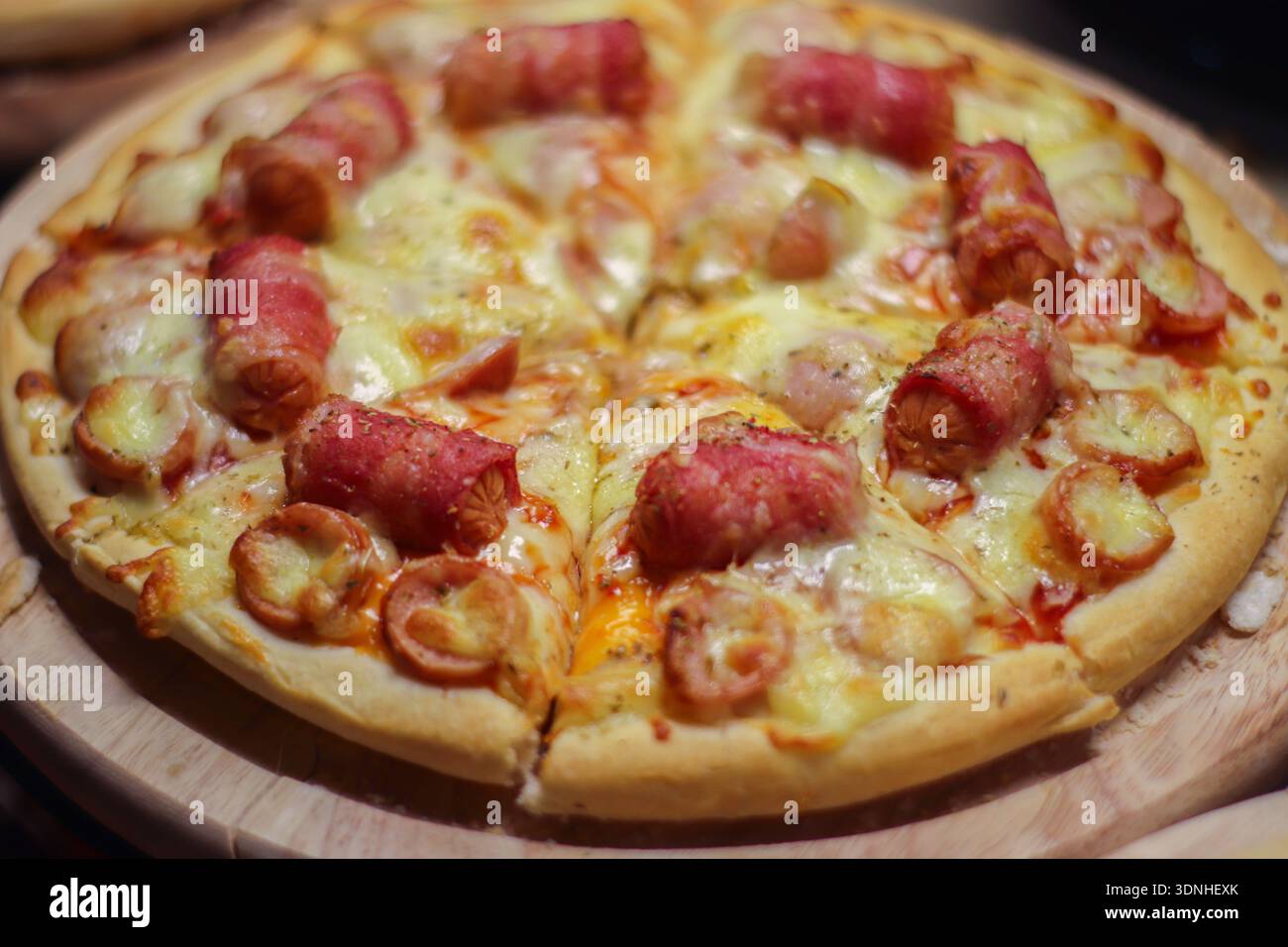 Primo piano di una deliziosa pizza con salsicce e pancetta. Immagini alimentari di alta qualità per menu di ristoranti, blog e pubblicità di fast food. Foto Stock