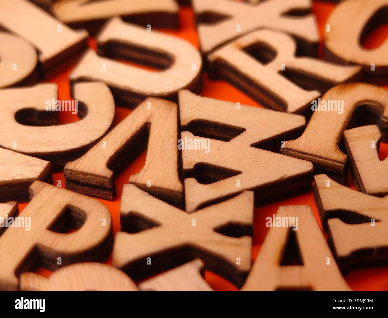 L'immagine mostra una raccolta di piccole lettere dell'alfabeto in legno non rifinite. Foto Stock