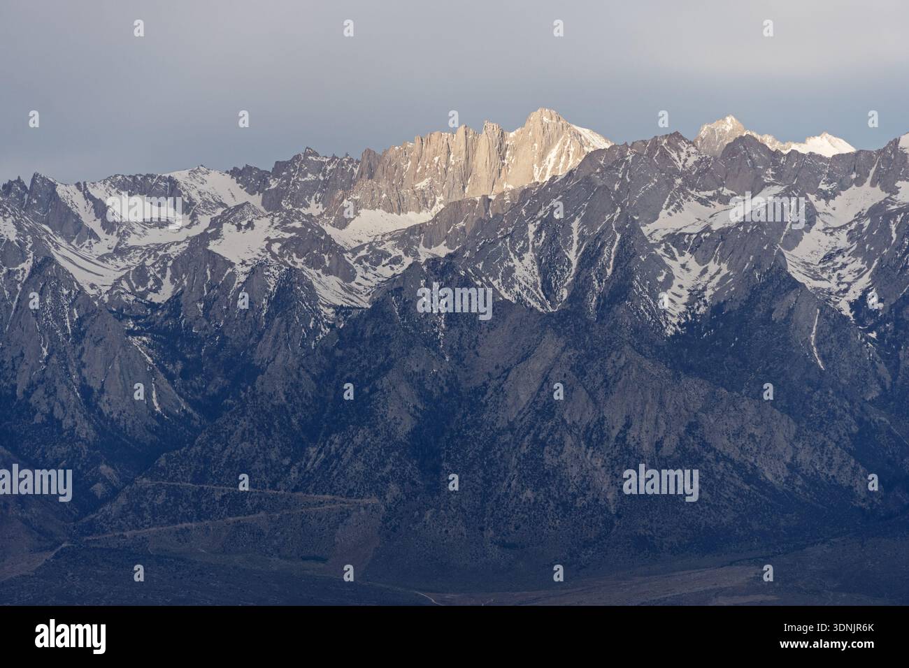 Il sole attraversa le nuvole e illumina la parete est del Monte Whitney, la vetta più alta degli Stati Uniti contigui Foto Stock
