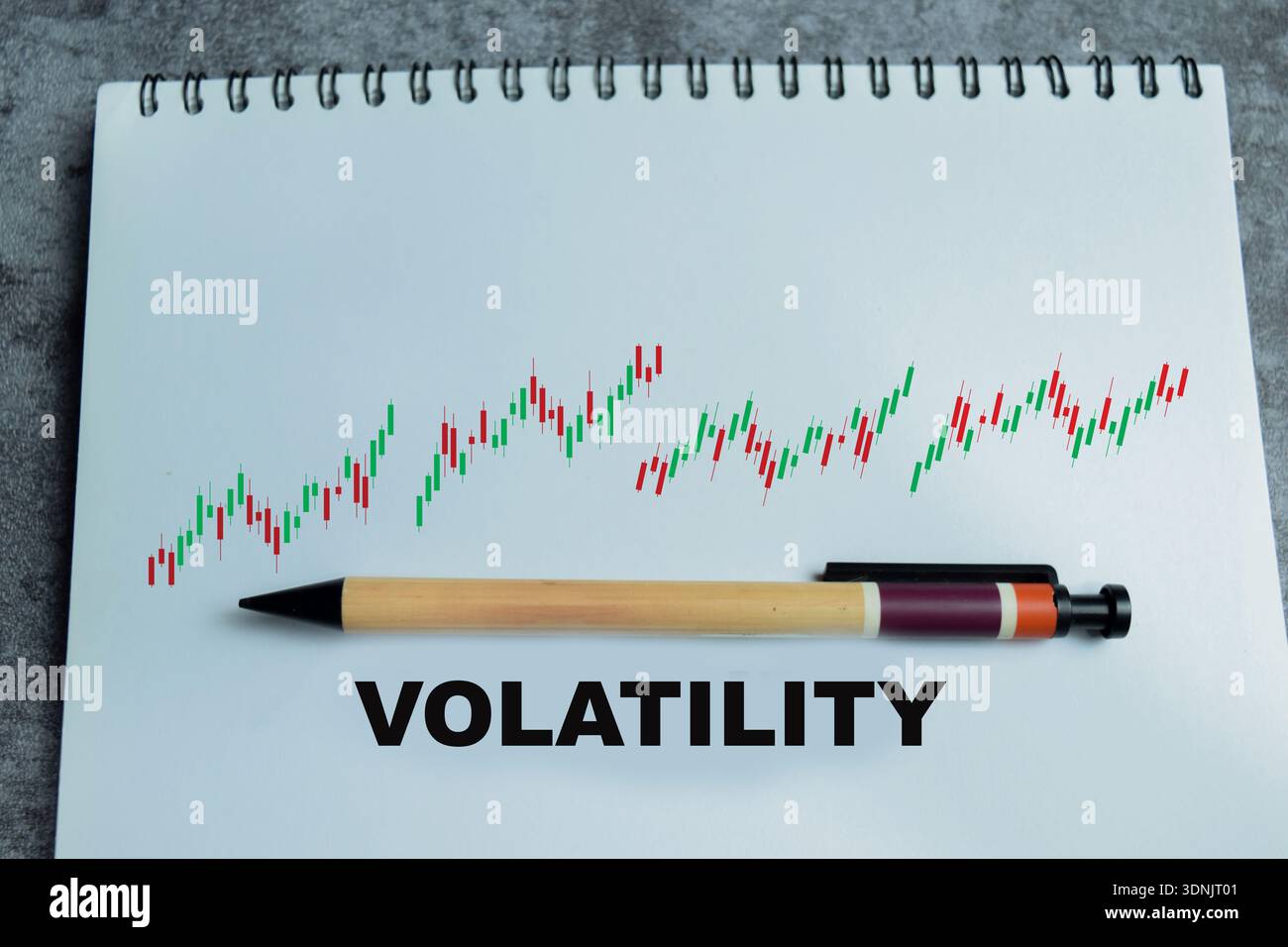 Concetto di volatilità del mercato scrivere su libro con isolato su tavolo di legno. Fluttuazione del mercato azionario, incertezza finanziaria e rischio di investimento Foto Stock