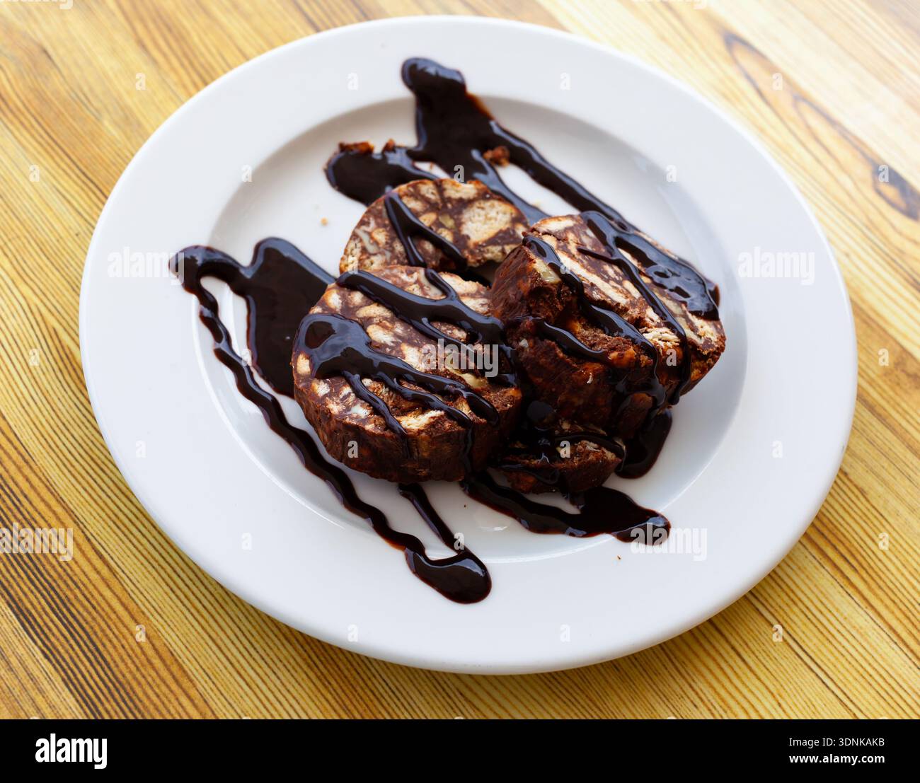 Torta arrotolata al cioccolato servita con noce sul piatto Foto Stock