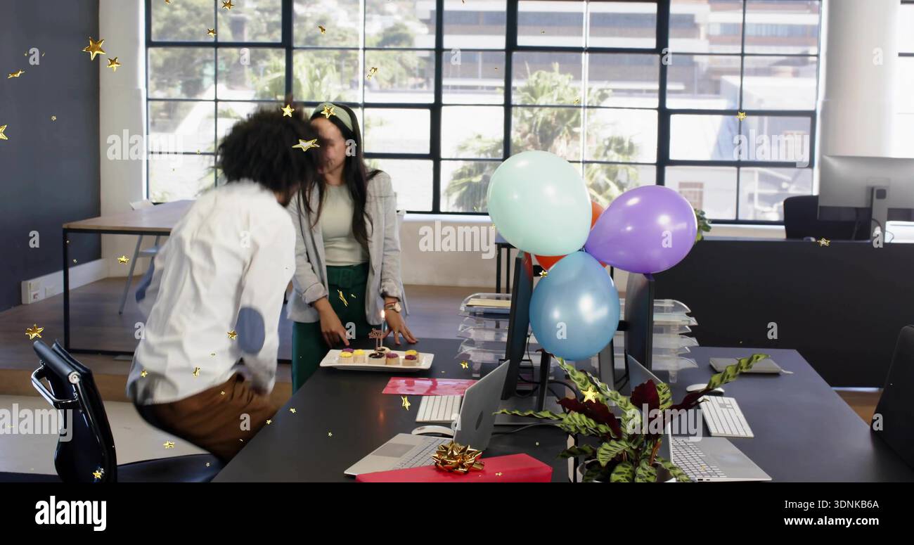 Sistemare due colleghi in abiti da lavoro, mettere cupcake sulla scrivania in ufficio, con regali e palloncini Foto Stock