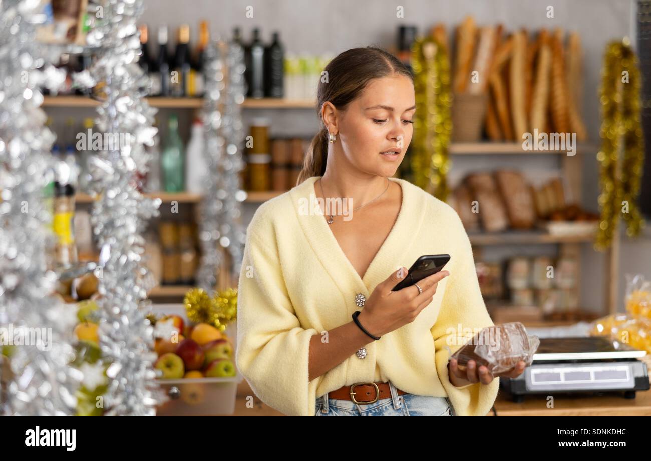 Donna che scansiona il codice qr sul formaggio Foto Stock