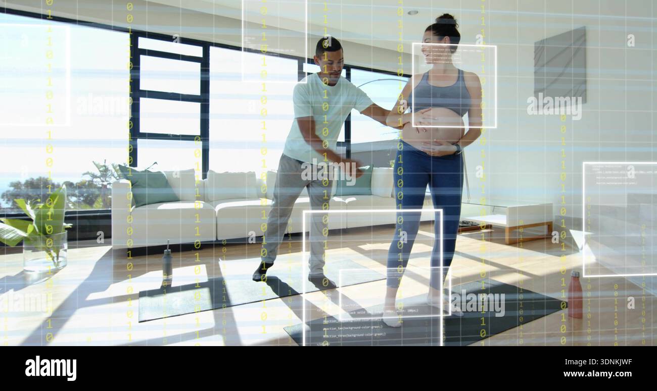 L'istruttore guida il cliente incinta indossando un abbigliamento sportivo su un tappeto nel soggiorno vicino alle finestre, con rivestimento olografico Foto Stock