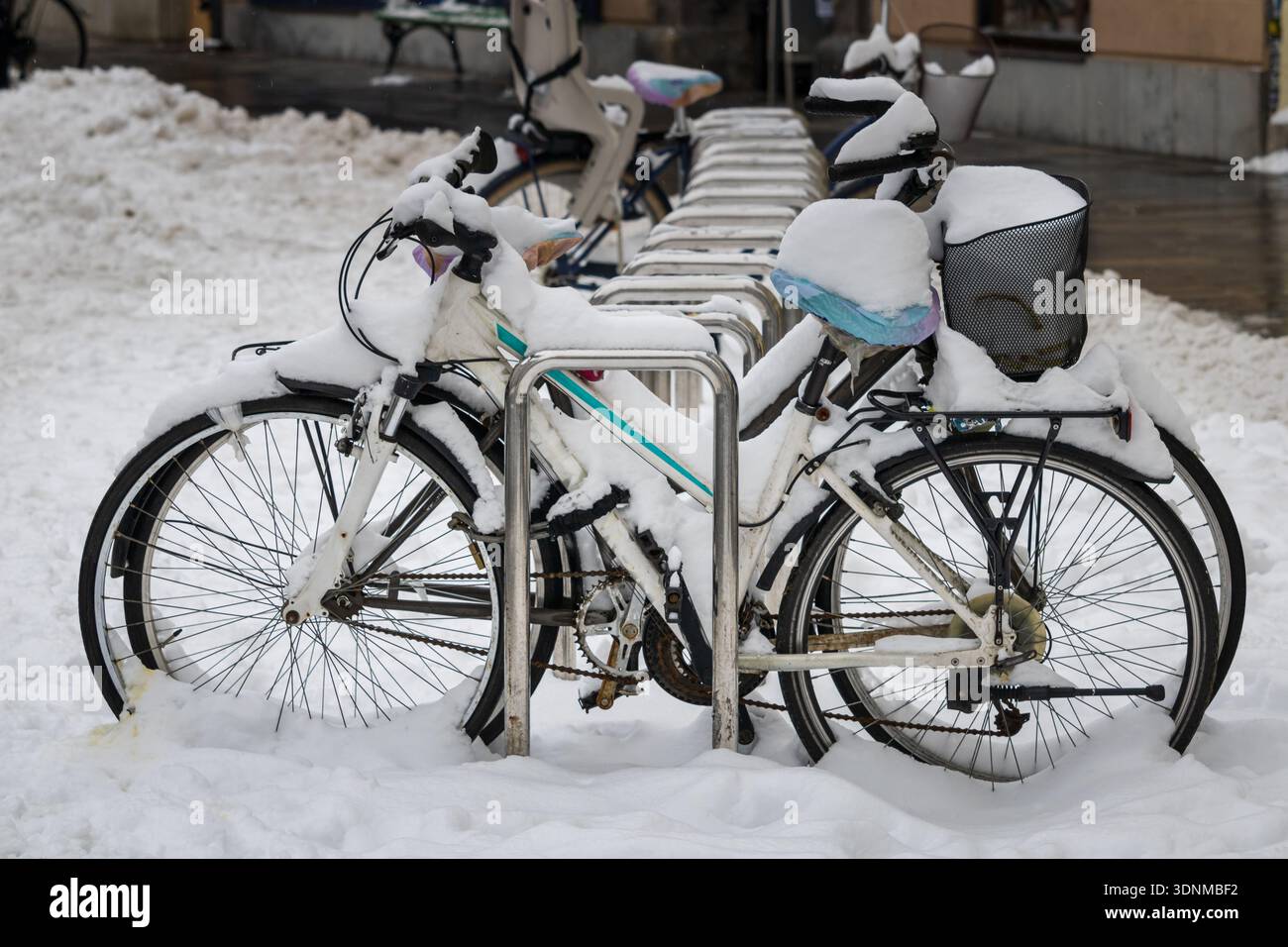 biciclette coperte di neve parcheggiate in inverno Foto Stock