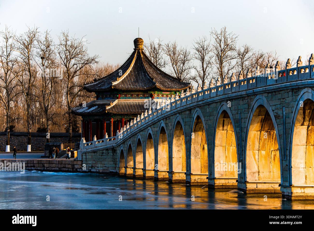 Il ponte del diciassettesimo arco al Palazzo d'Estate di Pechino illuminato dal famoso fenomeno della "luce dorata attraverso gli archi" al tramonto. Foto Stock
