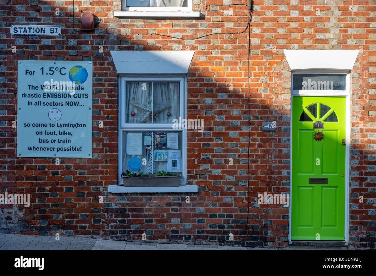 Casa in Station Street a Lymington con poster che invitano i visitatori a venire in città utilizzando mezzi di trasporto "climaticamente compatibili". Foto Stock