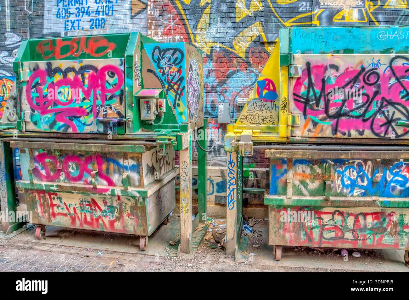 Due cassonetti sono ricoperti di graffiti. C'è la parola "guanto" Foto Stock