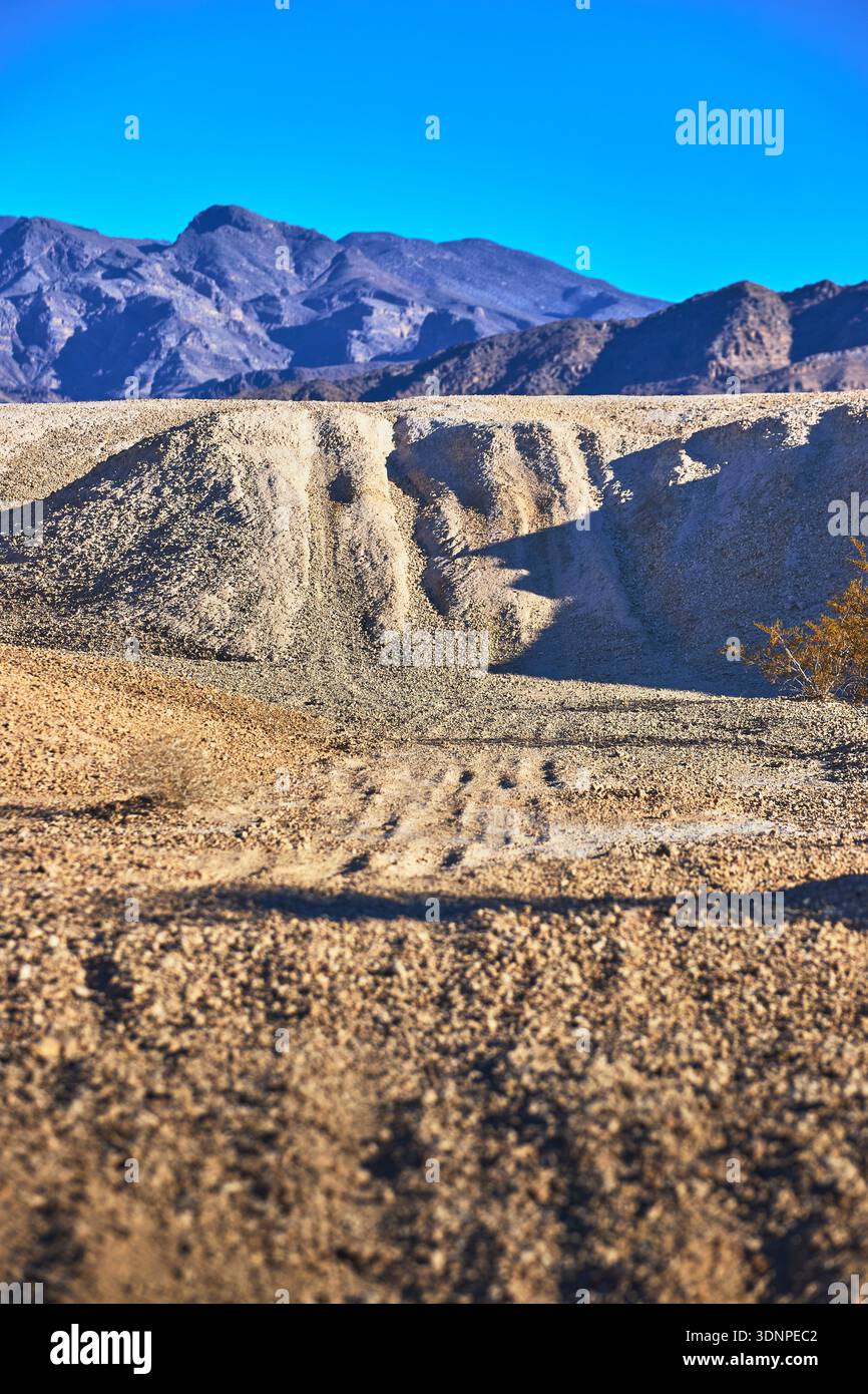 Desert Hills Gravel Mounds e Distant Mountains a Golden Hour Foto Stock