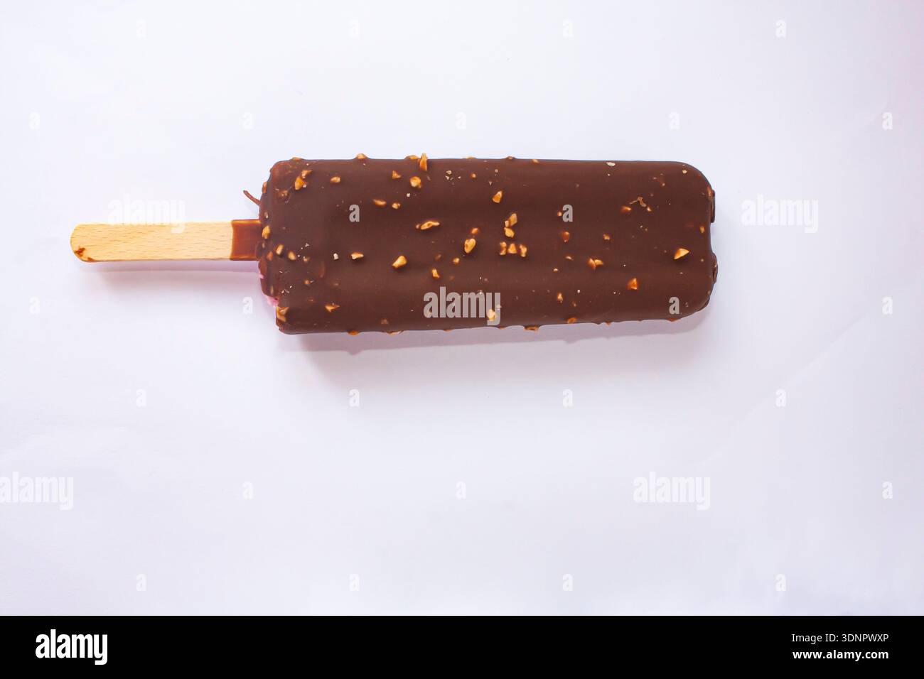 Gelato al cioccolato con noci su un bastoncino Foto Stock