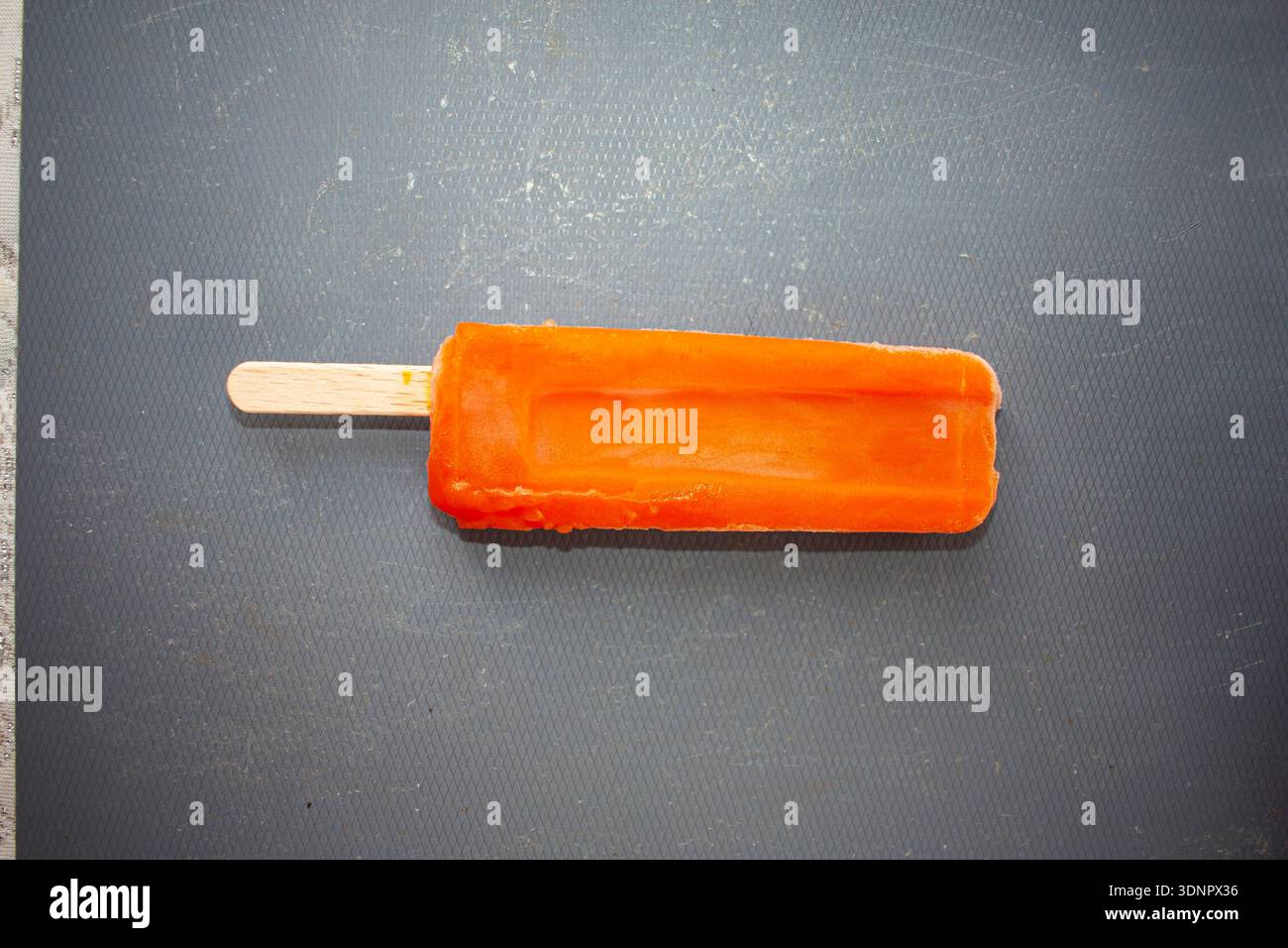 Il gelato al lolly d'arancia si scioglie Foto Stock