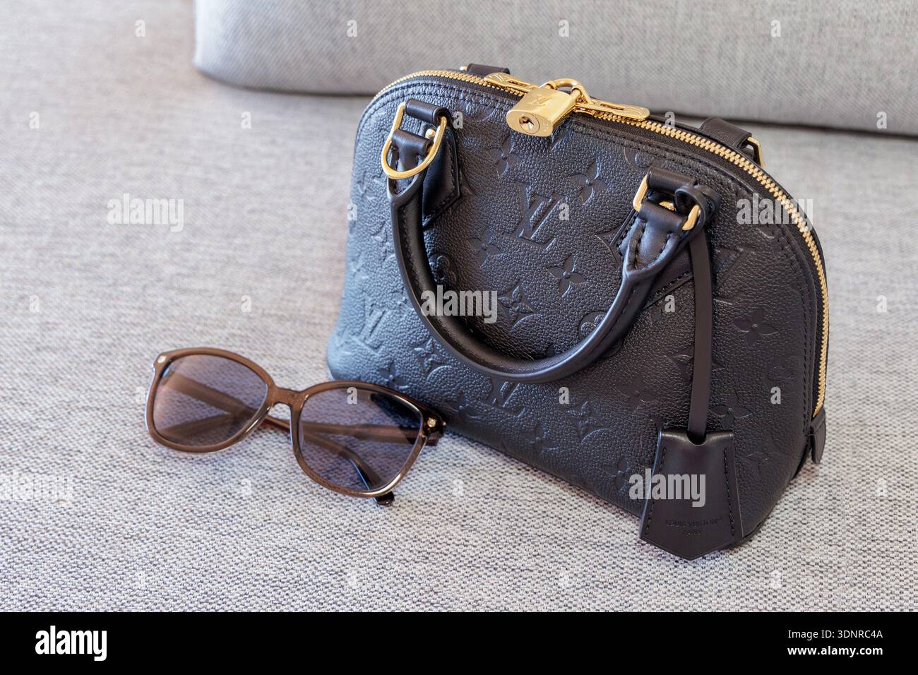 Borsa Alma nera Louis Vuitton con occhiali da soleNessuna autorizzazione di proprietà ottenuta. Solo per uso editoriale; non per layout commerciali o promozionali. Foto Stock