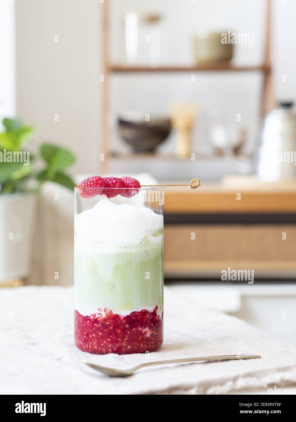 Latte matcha freddo a strati rinfrescante con purea di lamponi e condimento schiumoso Foto Stock