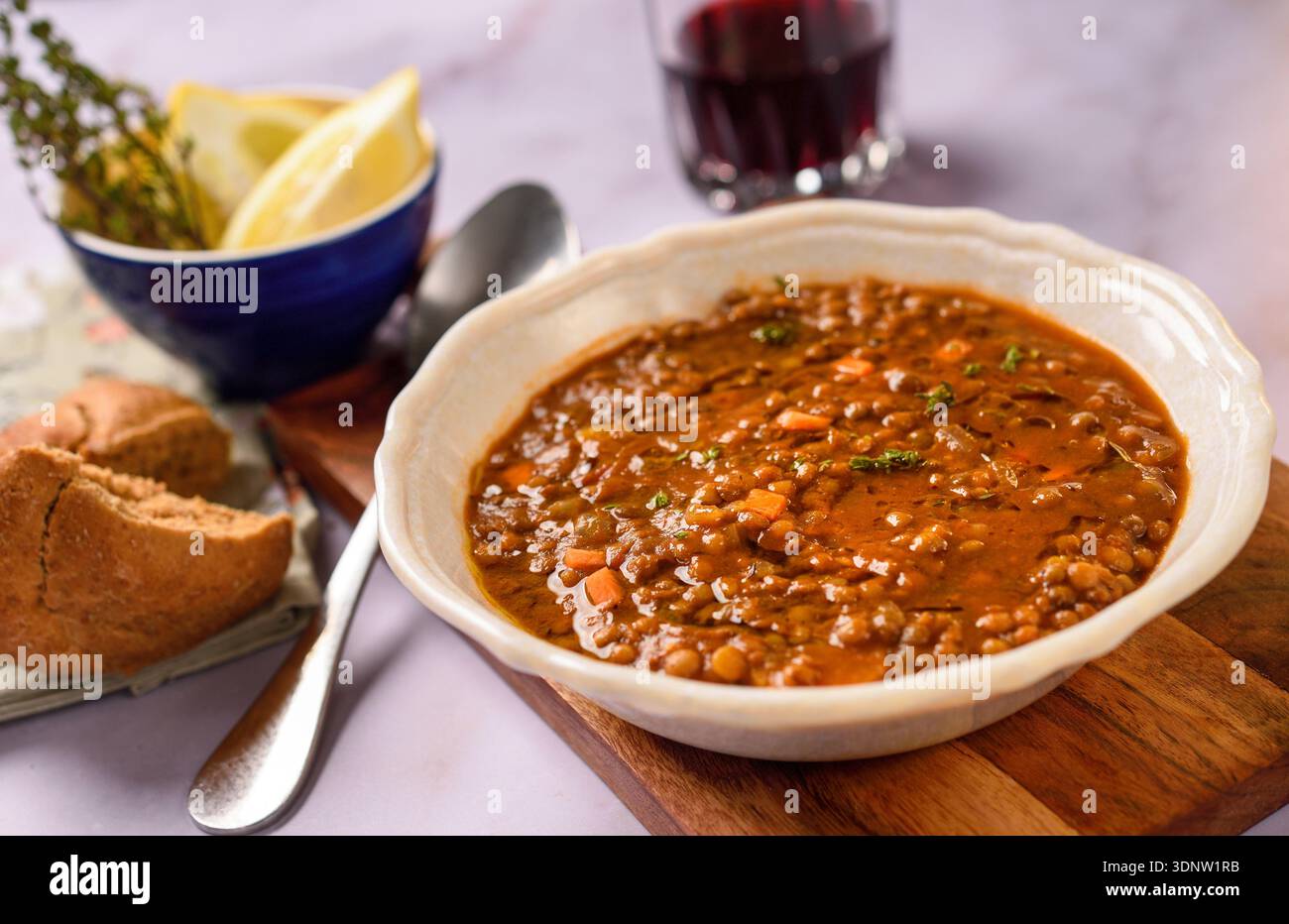 Tradizionale zuppa greca di lenticchie servita in un ristorante rustico con olio d'oliva, erbe aromatiche e stile mediterraneo da tavola. Foto Stock