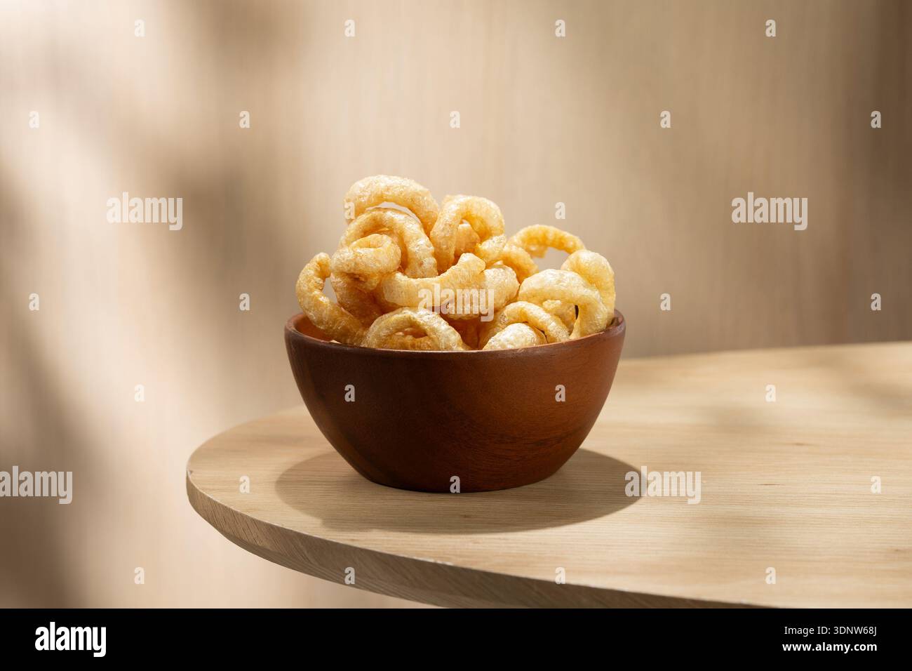 Kap Moo, croccanti croccanti crostate di maiale tailandese servite in una ciotola di legno su un tavolo leggero. Tradizionale spuntino tailandese con consistenza croccante, gusto saporito e minim naturale Foto Stock
