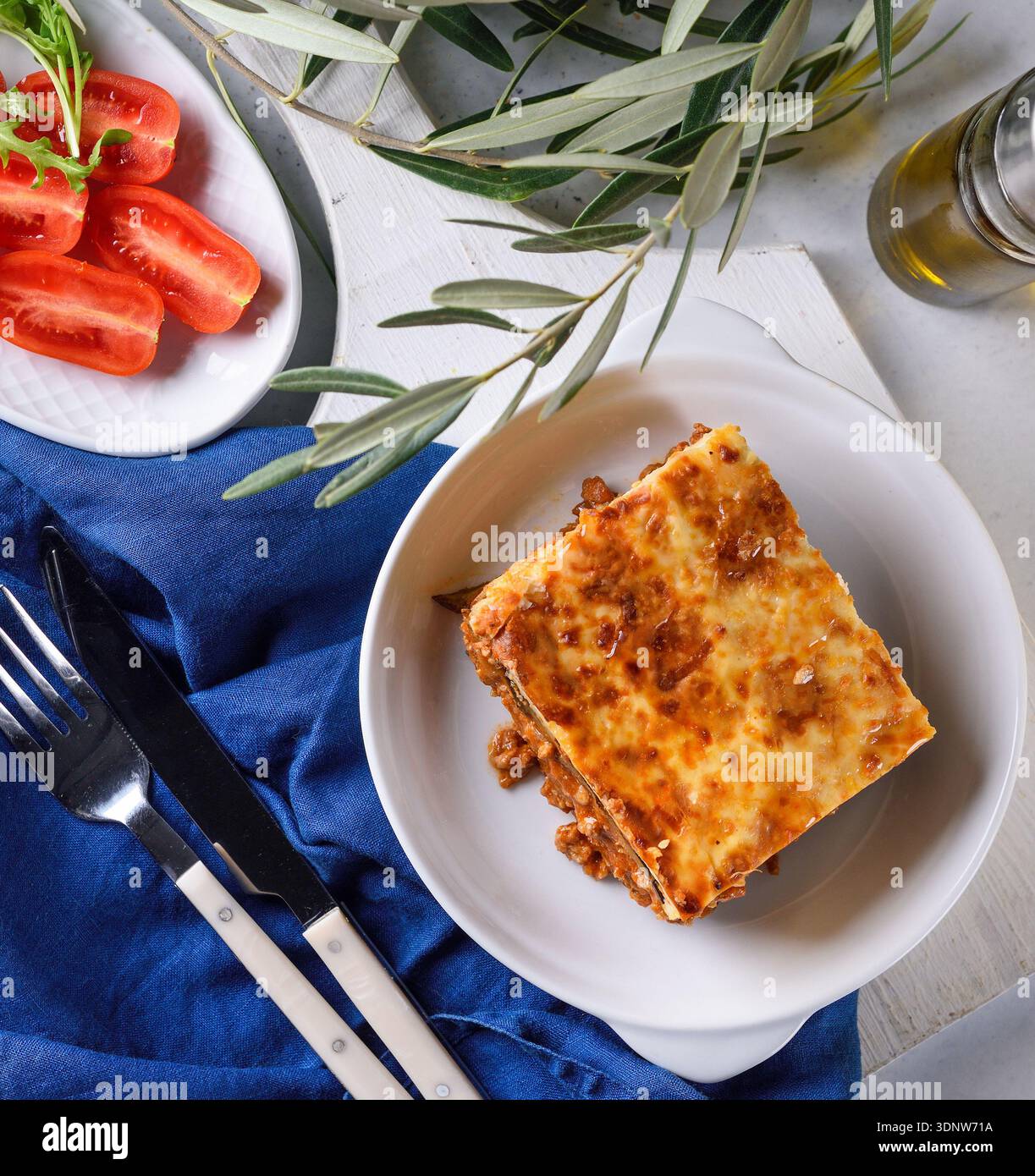 Tradizionale pastitsio greco al forno con carne macinata e salsa di béchamel servita in un ristorante rustico. Foto Stock
