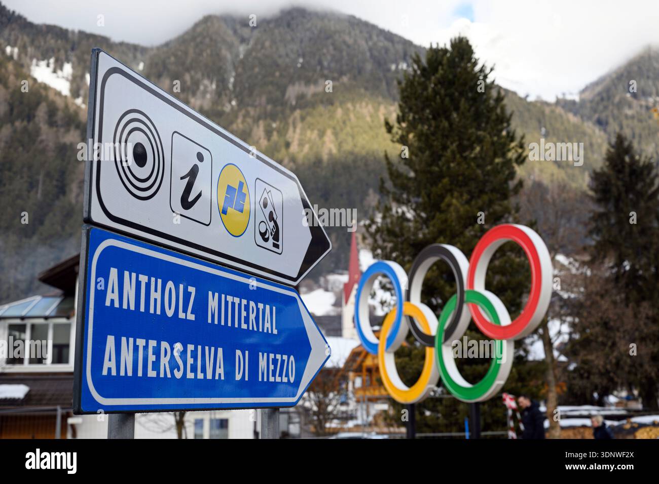 Anterselva, Italia. 12 febbraio 2026. Olimpia, Giochi Olimpici invernali Milano Cortina 2026, biathlon, gli anelli olimpici possono essere visti accanto ai cartelli. Crediti: Hendrik Schmidt/dpa/Alamy Live News Foto Stock