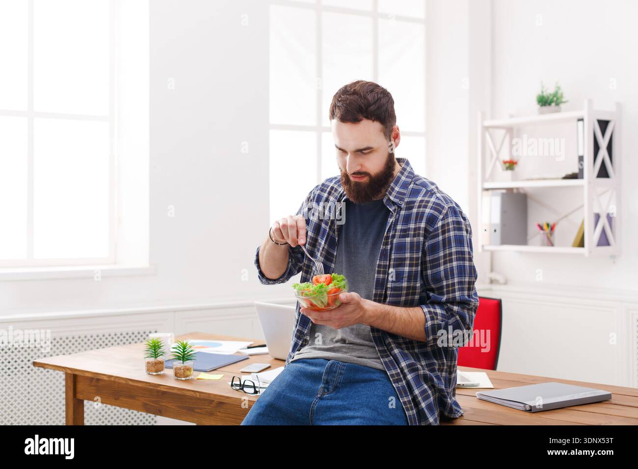 Il giovane uomo d'affari ha un sano pranzo d'affari in un moderno ufficio interno Foto Stock