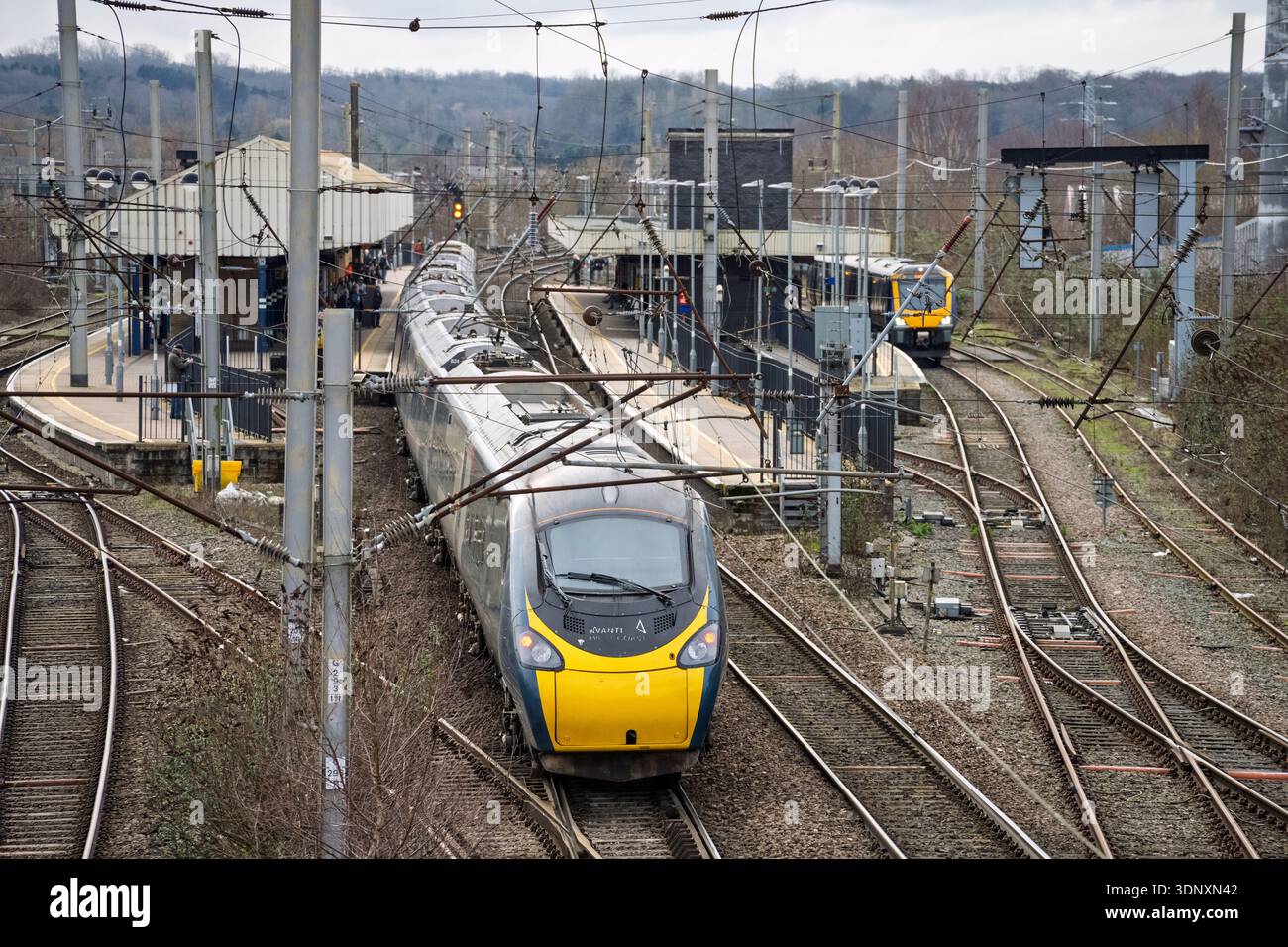Avanti Pendolino arriva a Warrington Bank Quay con la Northern Rail DMU al binario. Sito per la nuova stazione della Northern Powerhouse. Foto Stock
