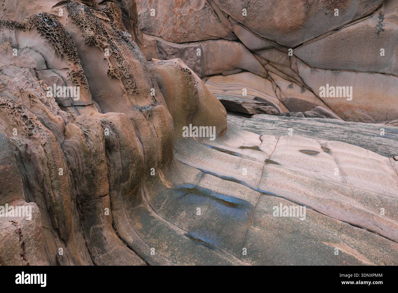 L'erosione dell'acqua forma rocce di arenaria vive sulla costa orientale delle Asturie, formando splendide forme che creano un paesaggio naturale unico. Foto Stock
