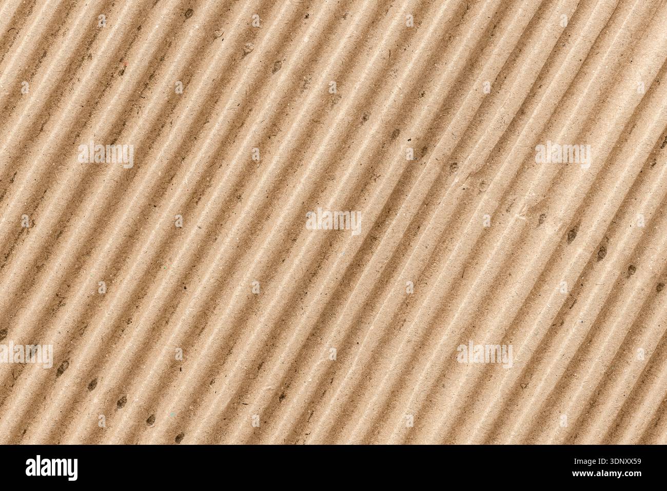 Vista ravvicinata del cartone ondulato che mostra la sua distinta consistenza marrone e il motivo rigato. Perfetto per progetti di design ecocompatibili e pacchetti Foto Stock