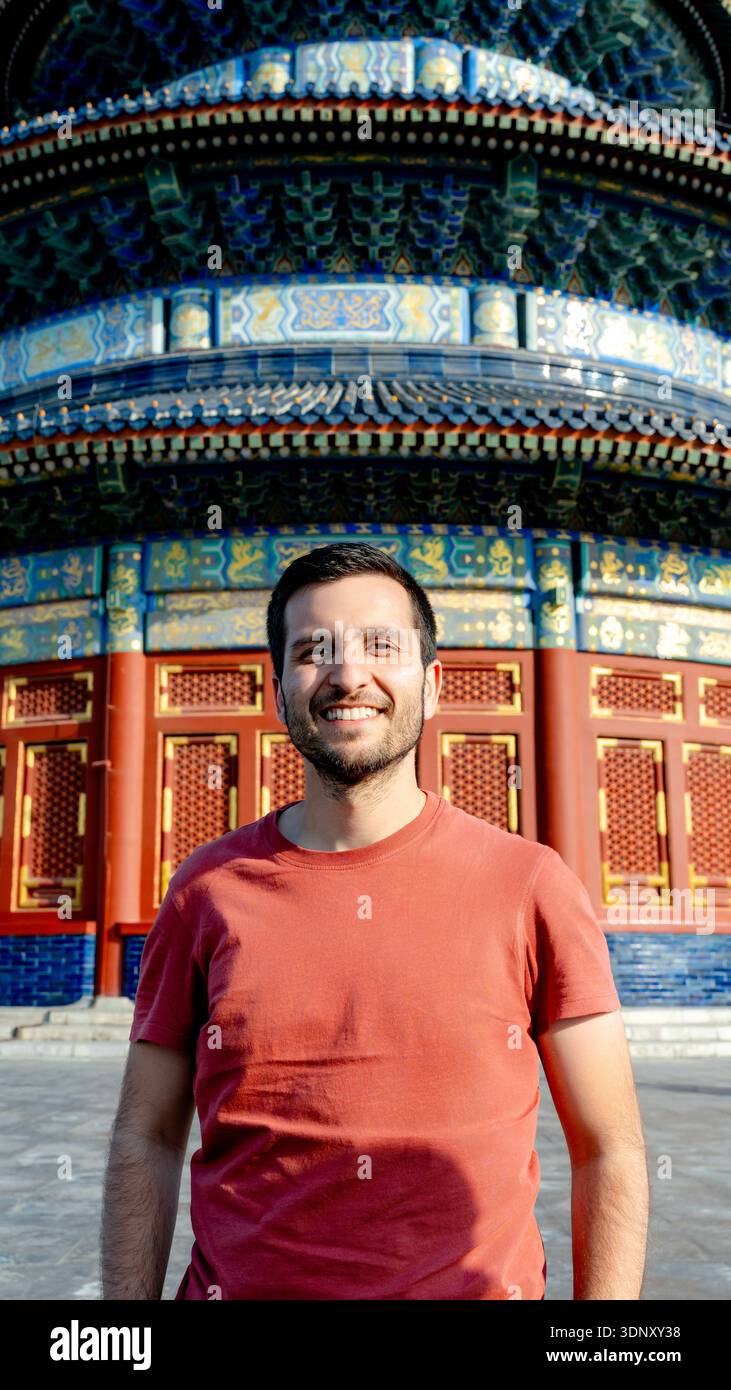 Un visitatore si erge davanti alla sala di preghiera ornata per buoni raccolti al Tempio del cielo, Pechino, Cina, e presenta i suoi archi splendidamente dettagliati Foto Stock