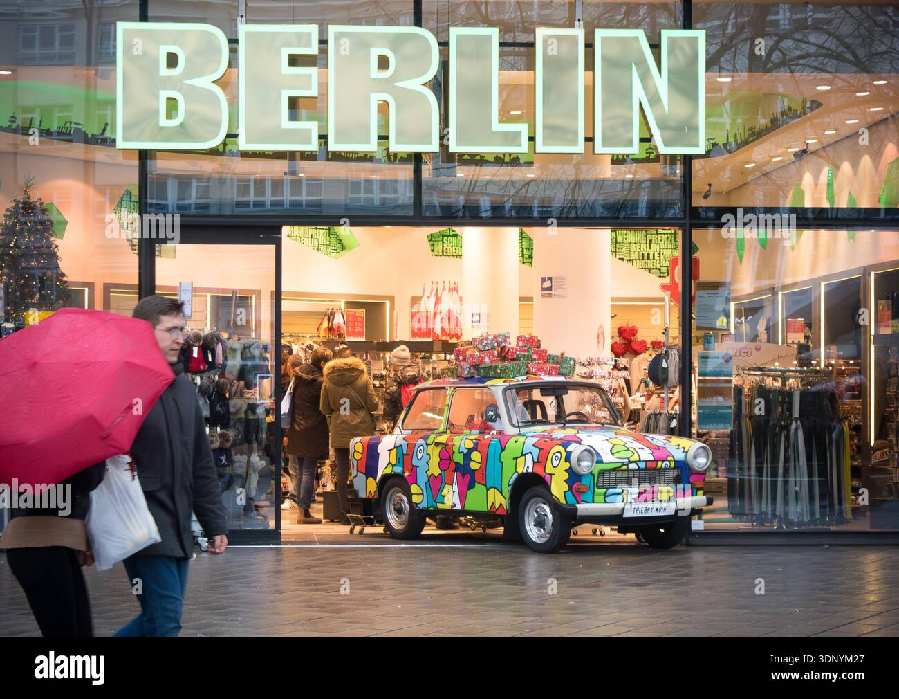 Colorata auto Trabant con opere d'arte esposte all'esterno di un negozio di souvenir di Berlino in inverno Foto Stock
