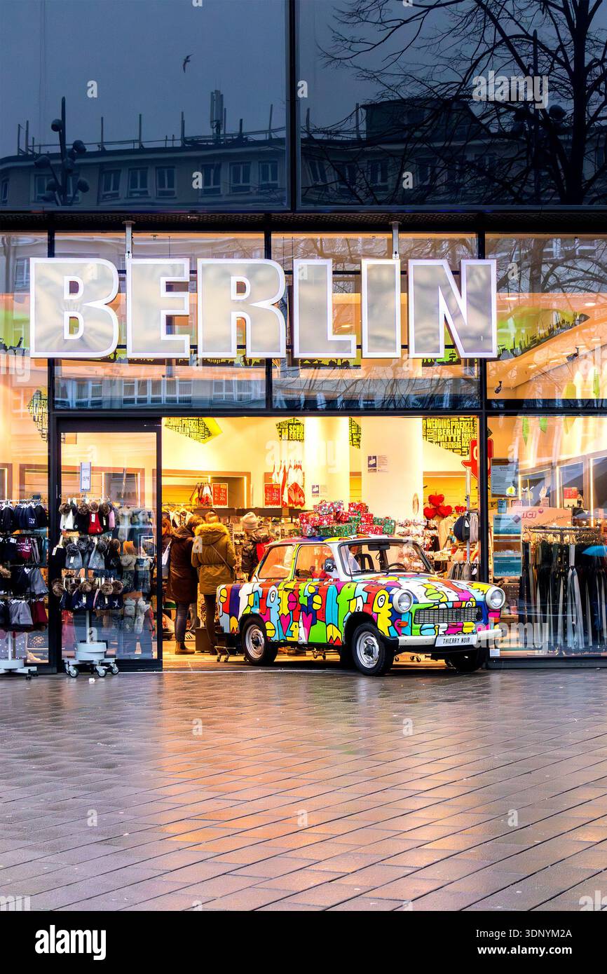 Colorata auto Trabant con opere d'arte esposte all'esterno di un negozio di souvenir di Berlino in inverno Foto Stock