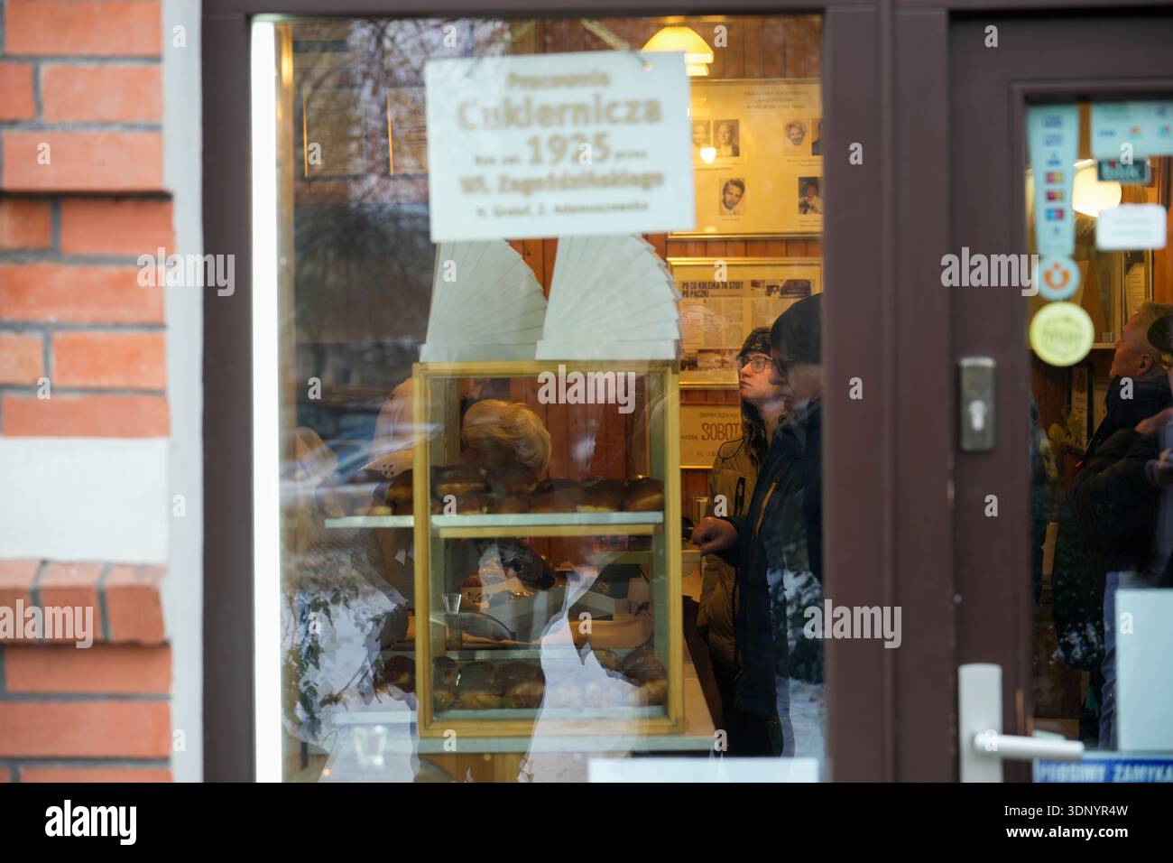 La gente aspetta all'interno della panetteria Zagozdzinski a Varsavia, Polonia, il 12 febbraio 2026. Ogni anno, l'ultimo giovedì prima della Quaresima, i polacchi stanno a lungo Foto Stock