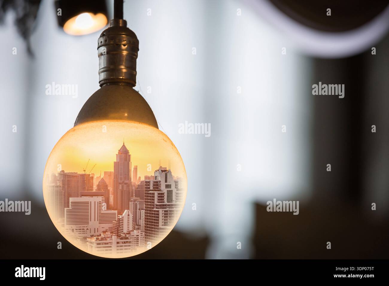 paesaggio urbano al tramonto nella lampadina a cerchio grande come business, globalizzazione, pensiero e idea. Foto Stock