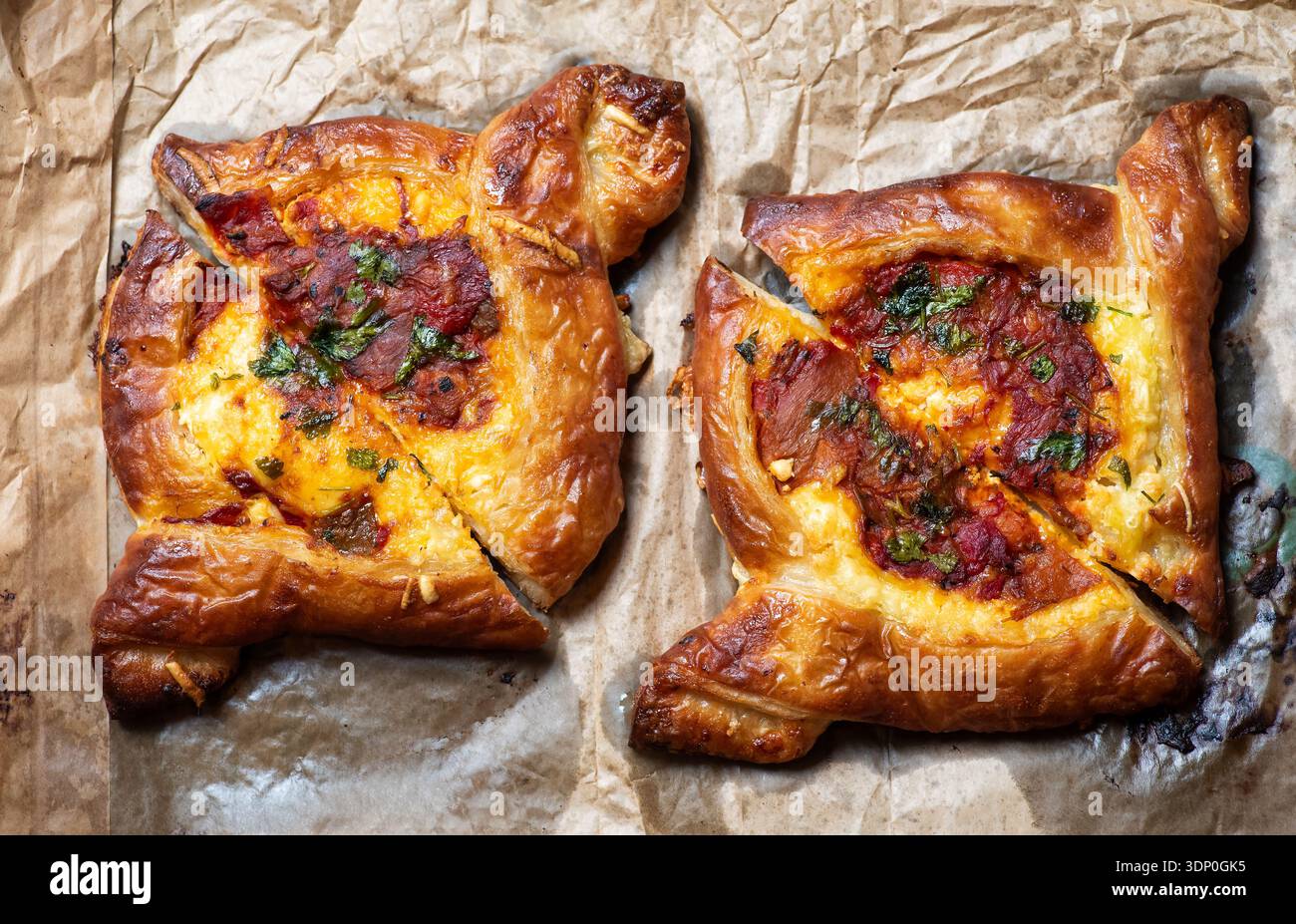 Due deliziosi pasticcini per pizza a forma di tartaruga dorata sono cotti alla perfezione. Sono disposti esteticamente sulla teglia da forno, ideali per una gastronomia Foto Stock