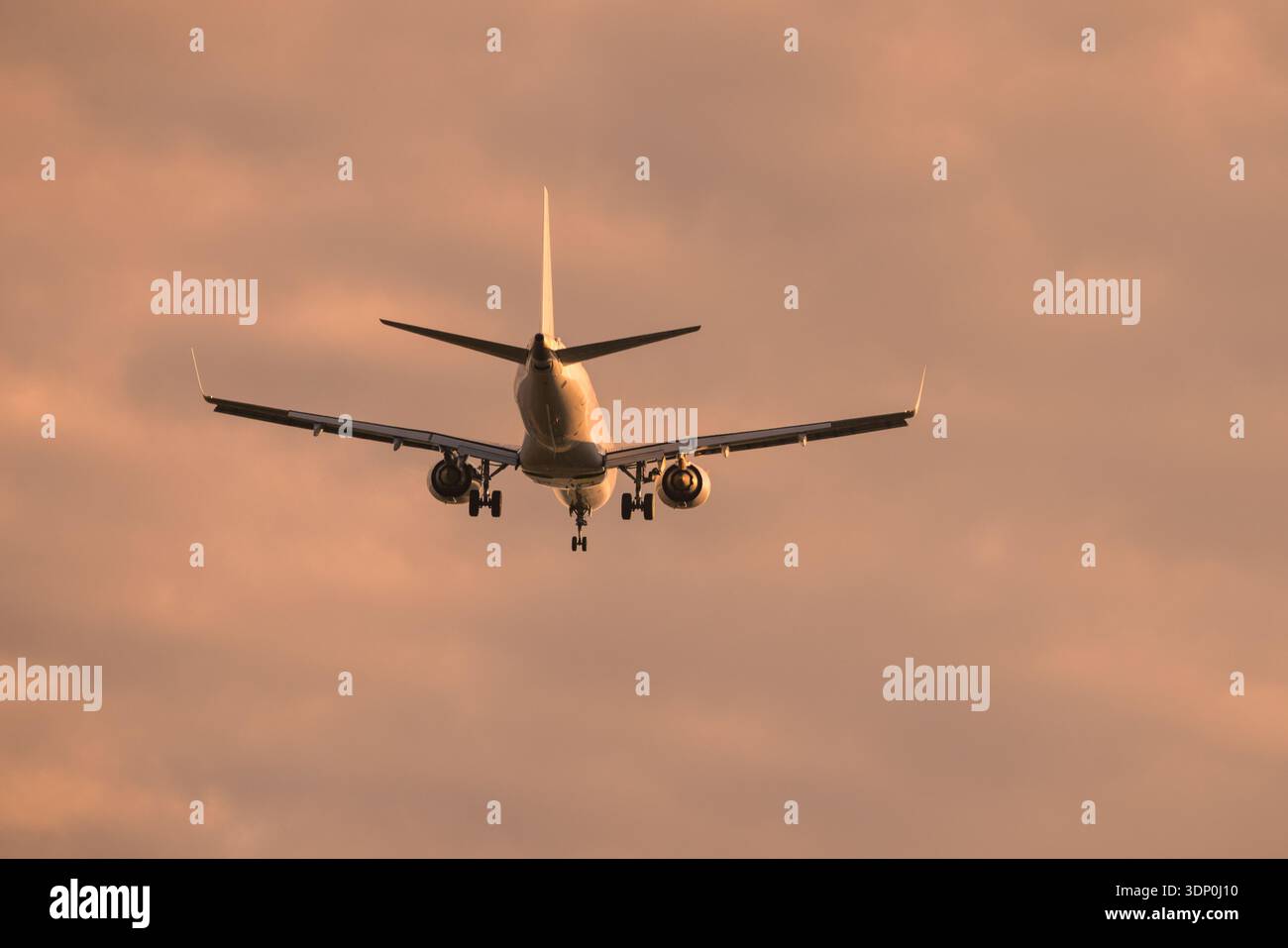 Aereo commerciale in avvicinamento alla pista durante un caldo tramonto Foto Stock