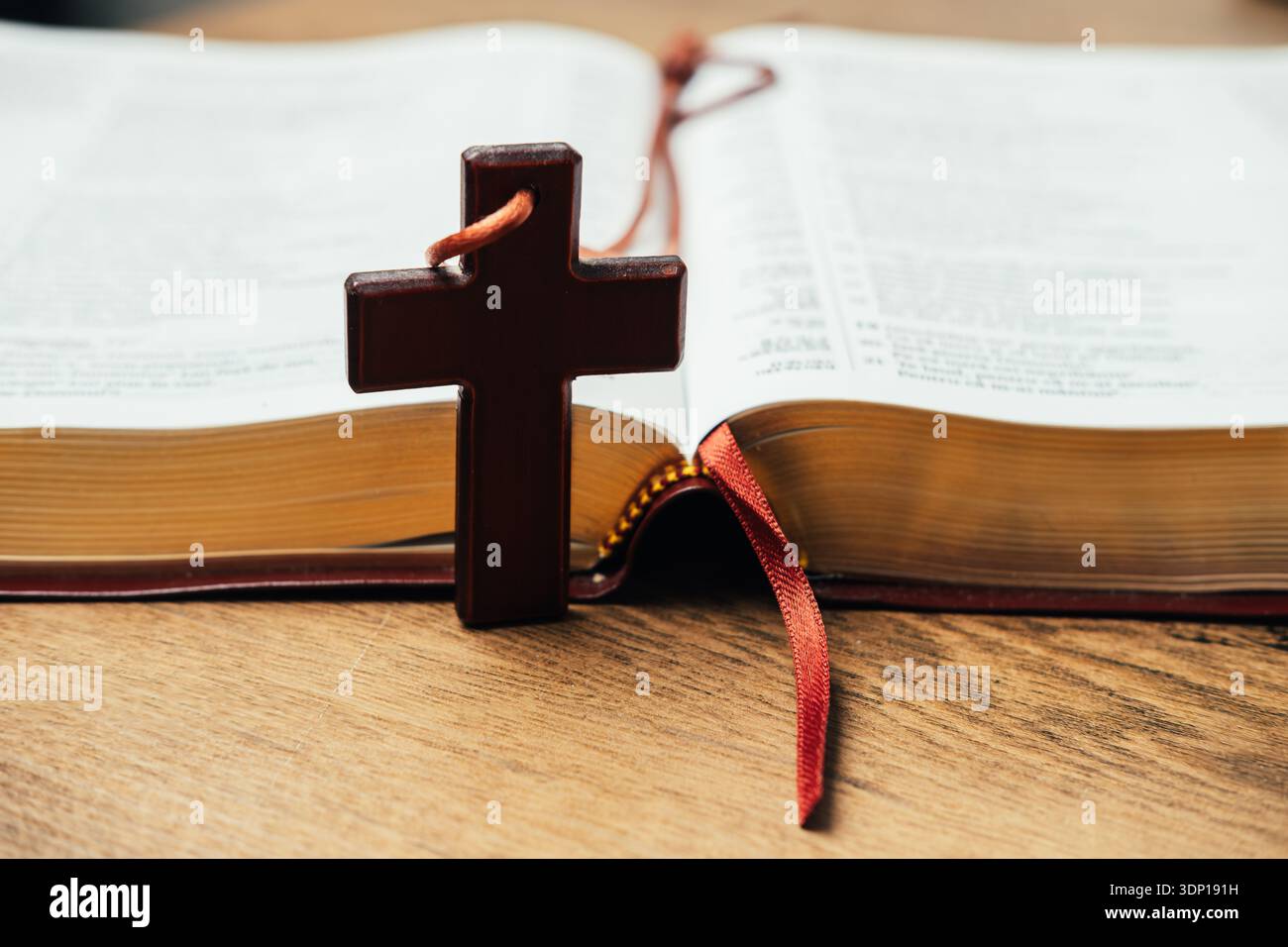Scena di preghiera che evidenzia la croce che riposa sulle pagine della Bibbia aperte con il marcatore del nastro Foto Stock